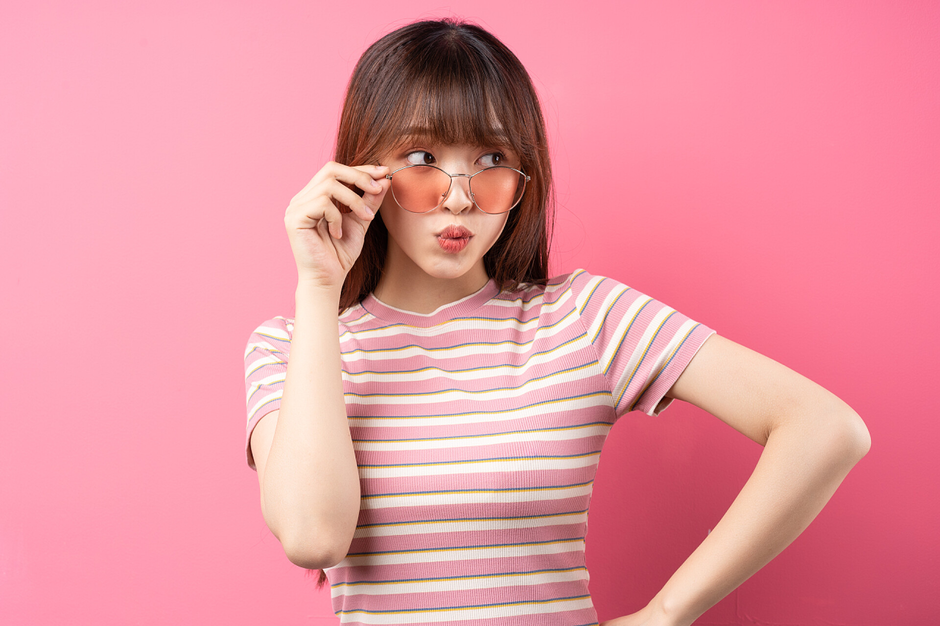 粉色背景前一个女人在拍照身穿粉色背景的粉色T恤的年轻亚洲女孩形象