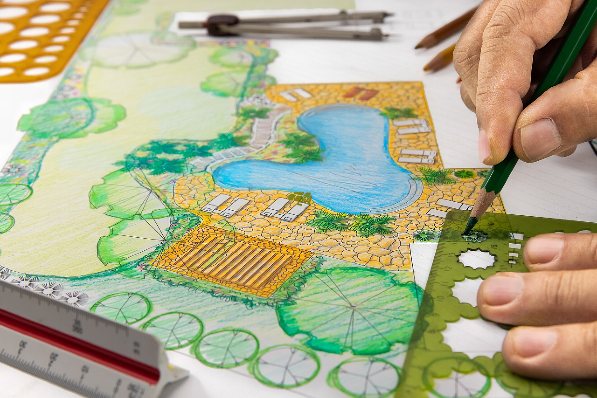 一个女人用尺子在画图纸别墅后院落花园及泳池设计计划.