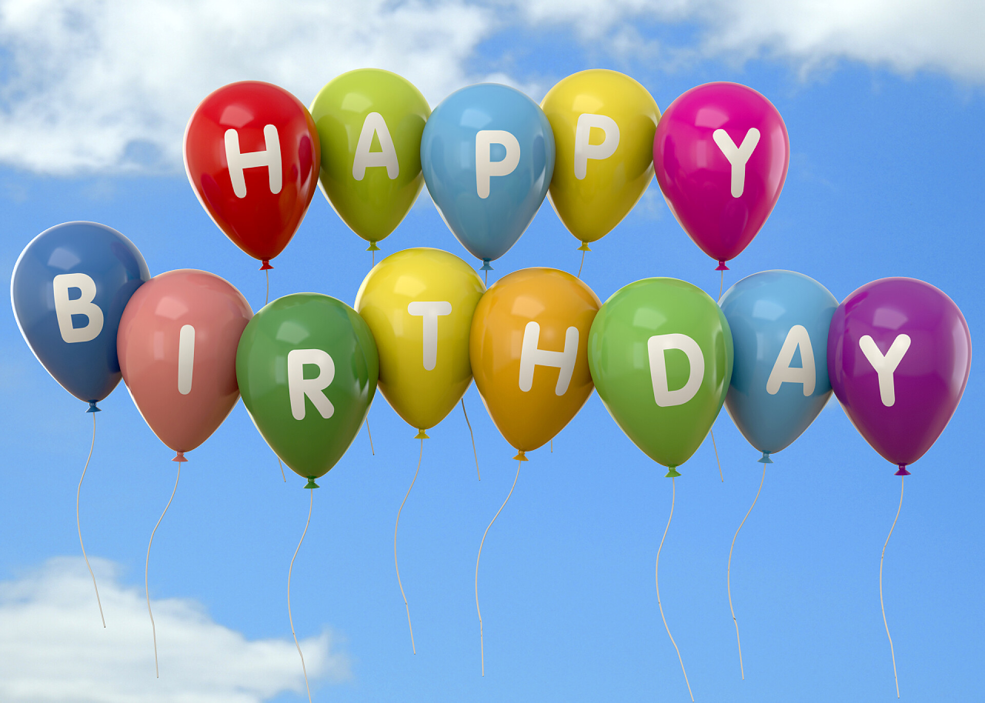 蓝天白云下的带有生日字母的气球