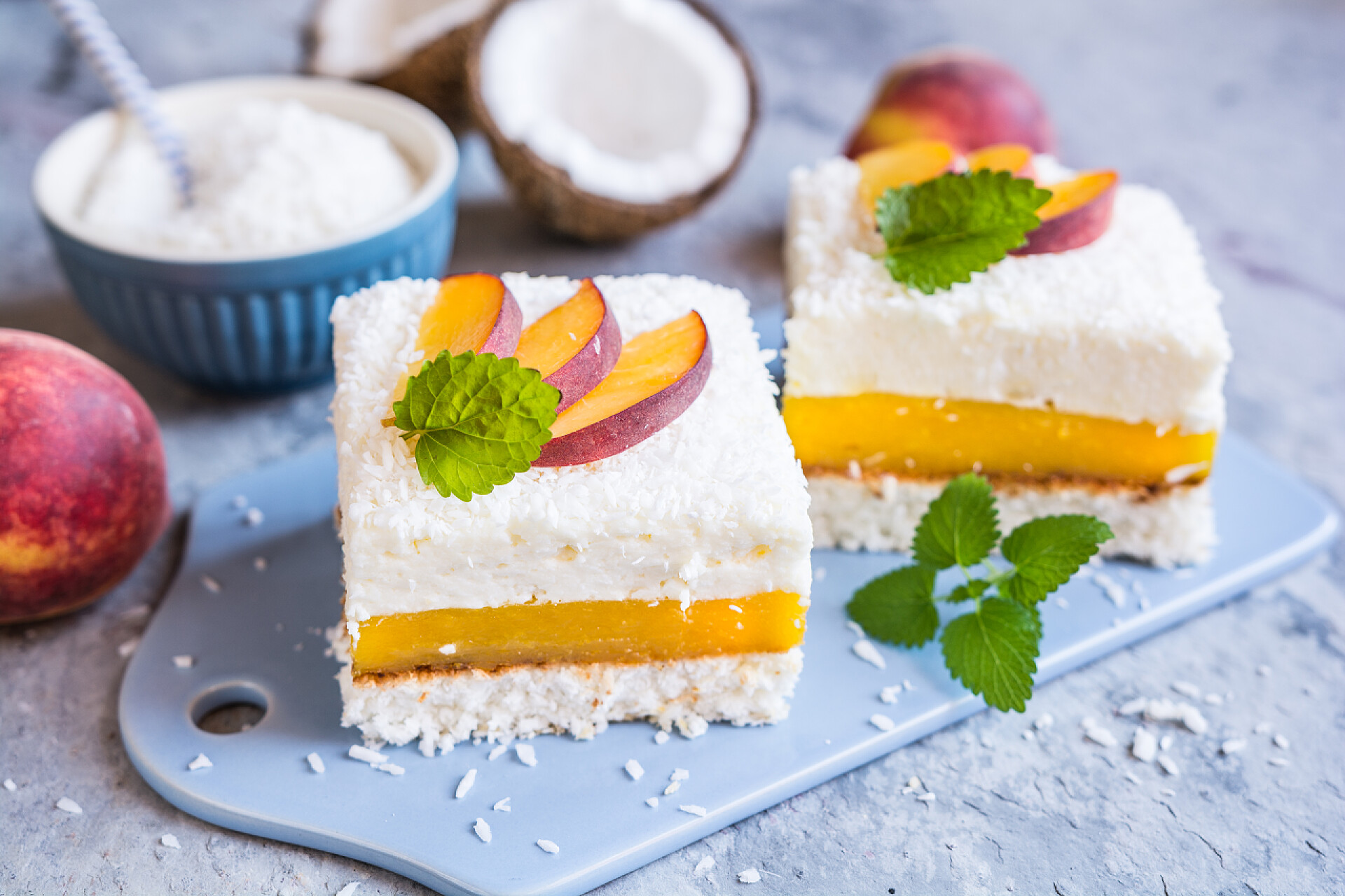 桌子上的两个甜品蛋糕用桃馅装饰椰子甜点，并配上新鲜水果片