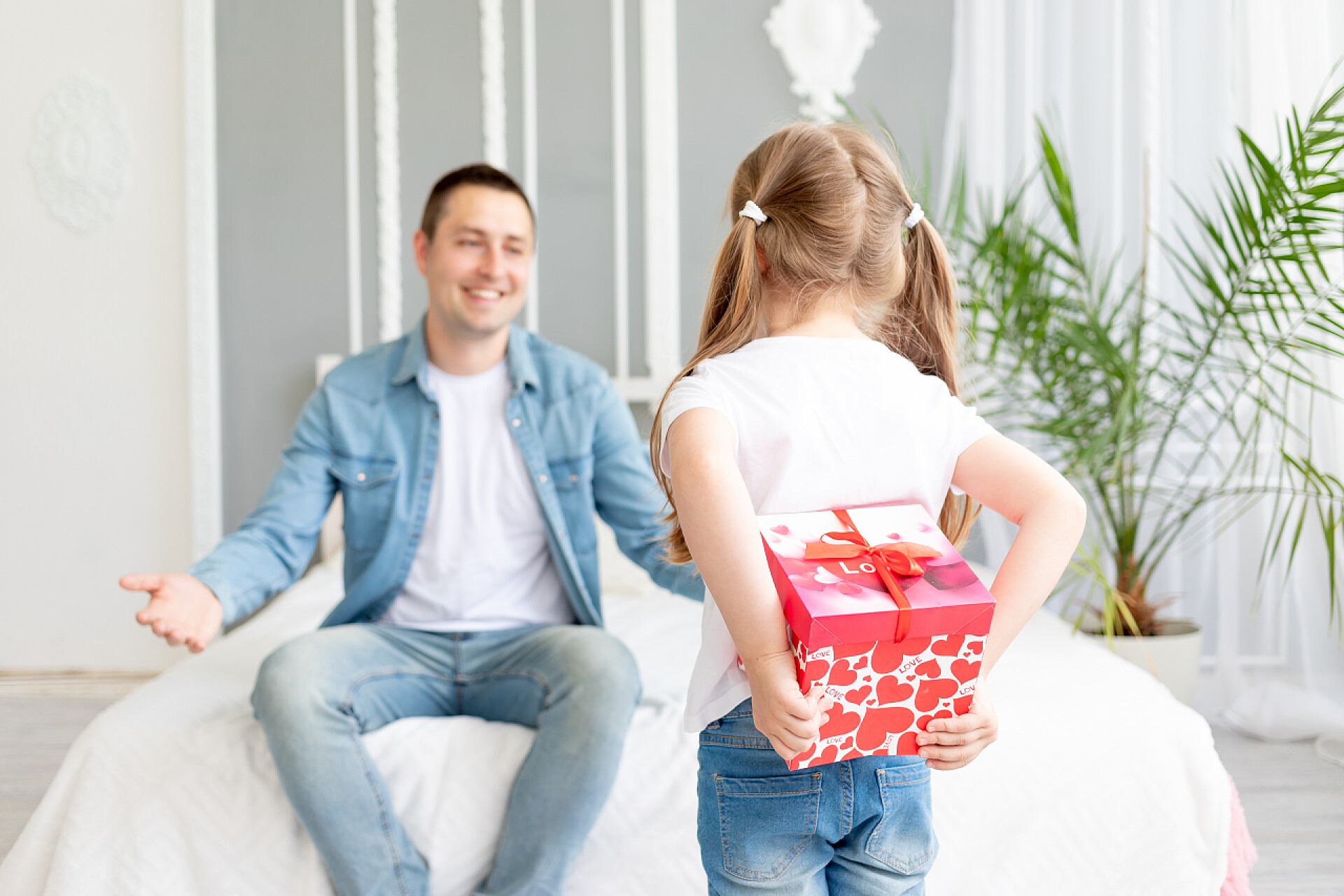 父亲节女儿准备礼物给爸爸3.女儿送给她心爱的父亲一份礼物，礼物藏在她身后，送给她幸福的家庭或父亲节