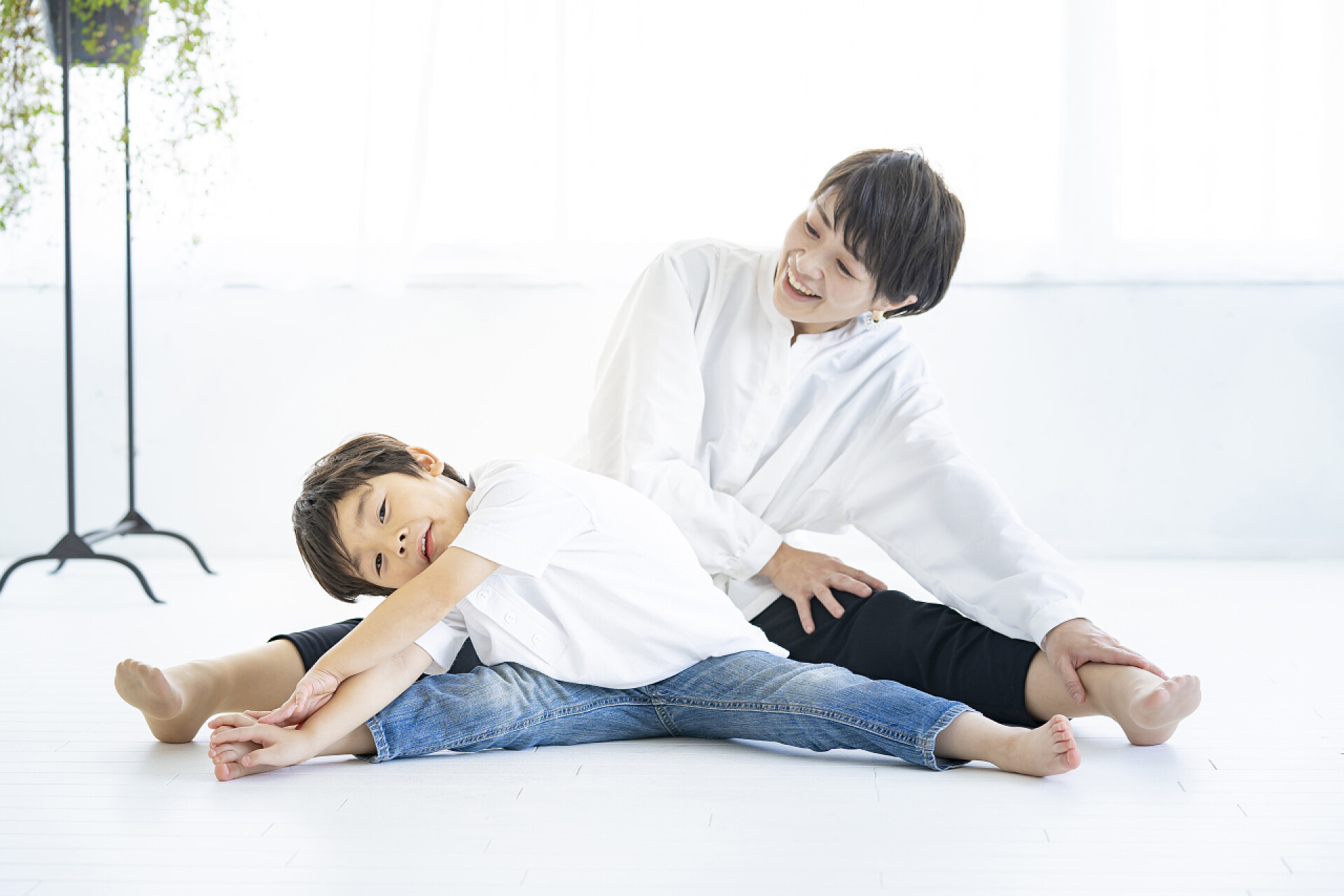 白色地面上的母子做瑜伽动作亚洲妈妈和她儿子在做瑜伽