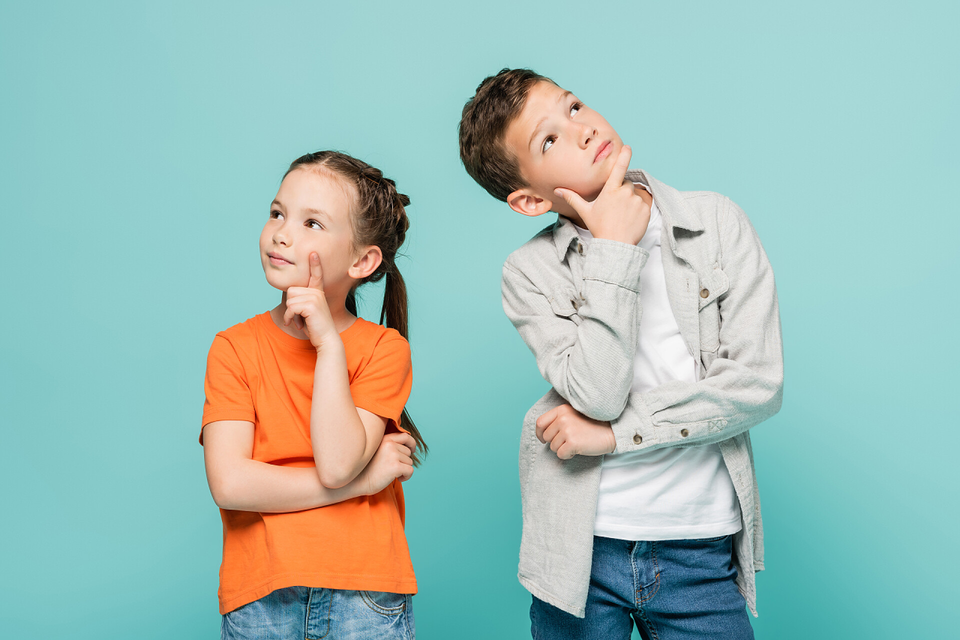 蓝色背景下的两个小孩在思考问题忧心忡忡的孩子望着别处，只想着孤独的蓝色 