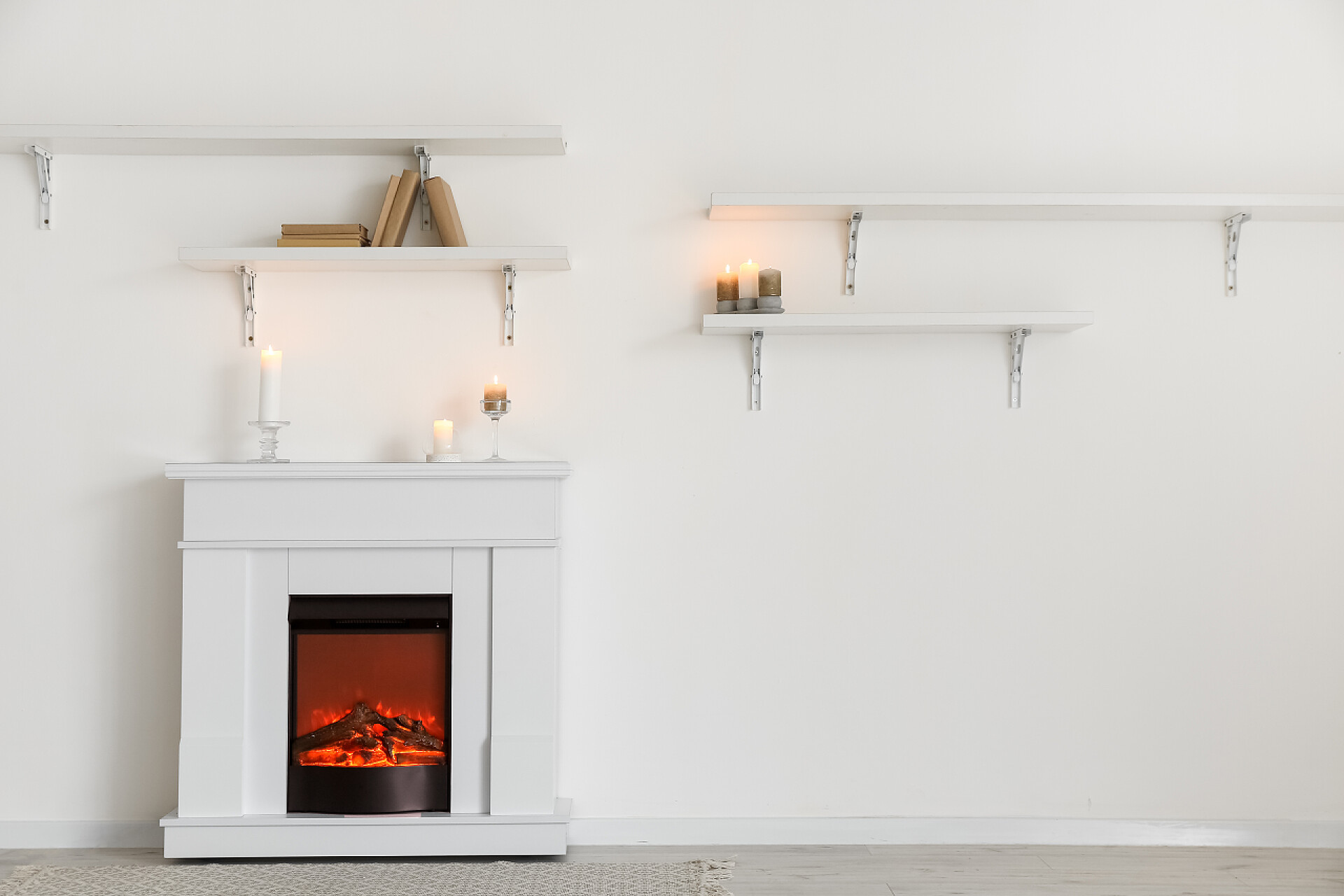 白色的墙壁上的白色架子和炉橱房间里靠近光墙的时尚壁炉