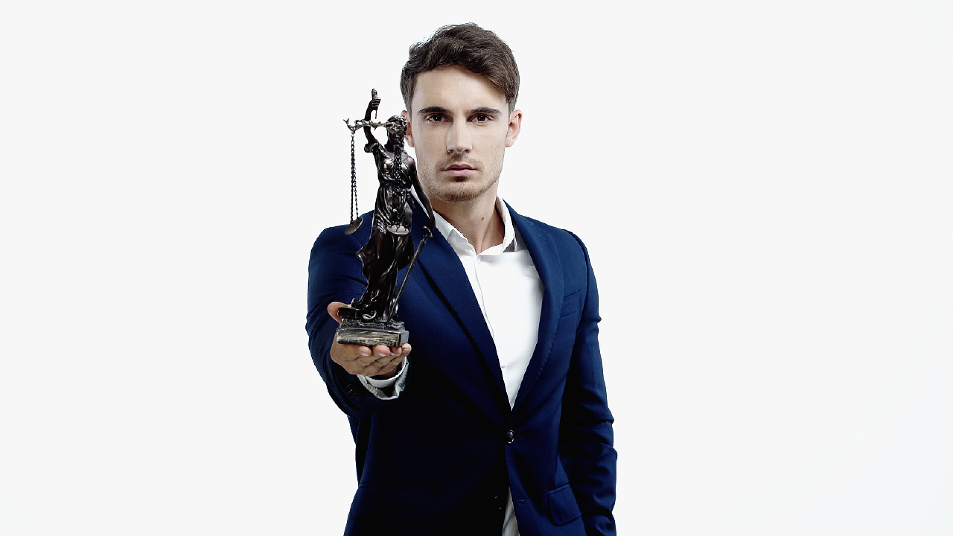 白色背景下拿着雕塑的男人穿着西服的律师手持女神像，看着被白色隔离的相机