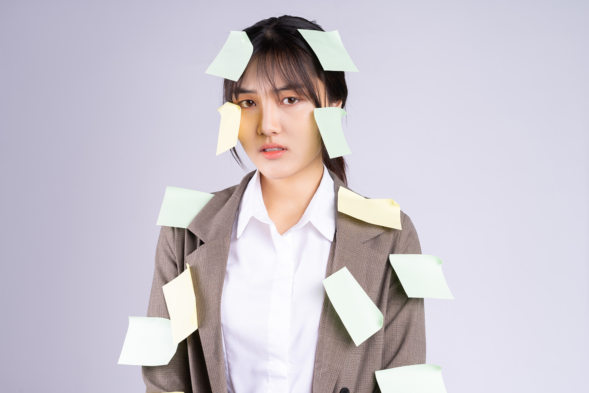 白色背景下一个贴满便利贴的女人年轻的亚洲女商人在截止日期前感到压力