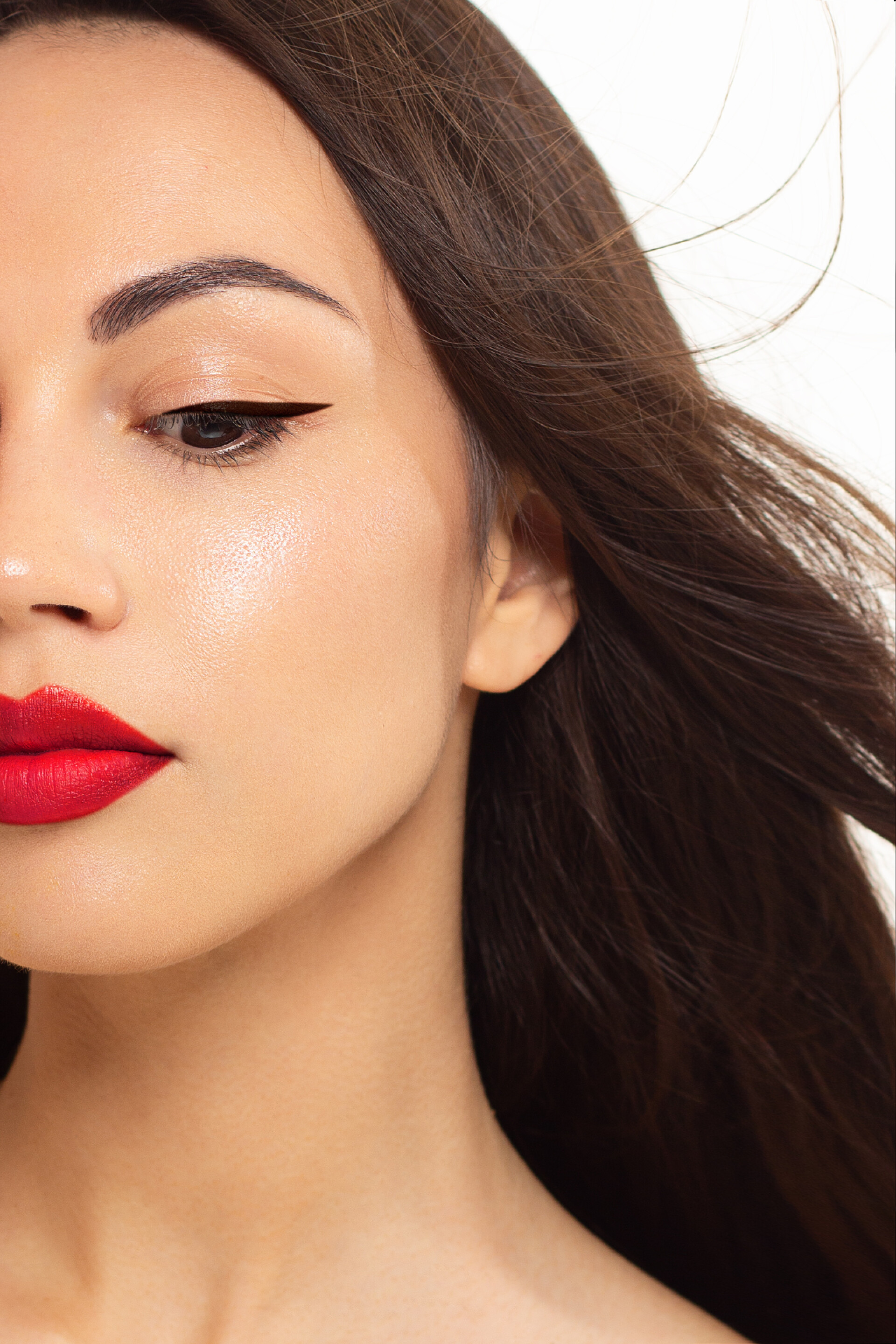 白色背景前的女人脸庞具有黑色化妆和长裙的高级时尚美女模特。红唇。黑色口红和白色皮肤。白色背景下孤立的时尚风格肖像