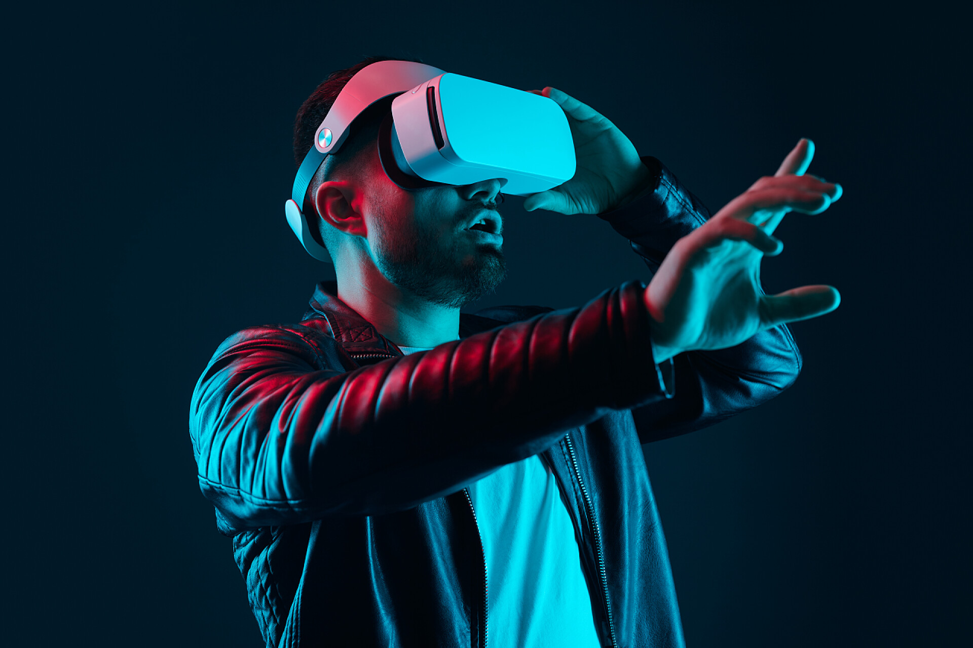 黑色背景前的一个男人戴着AR眼镜令人惊讶的人与虚拟现实的互动