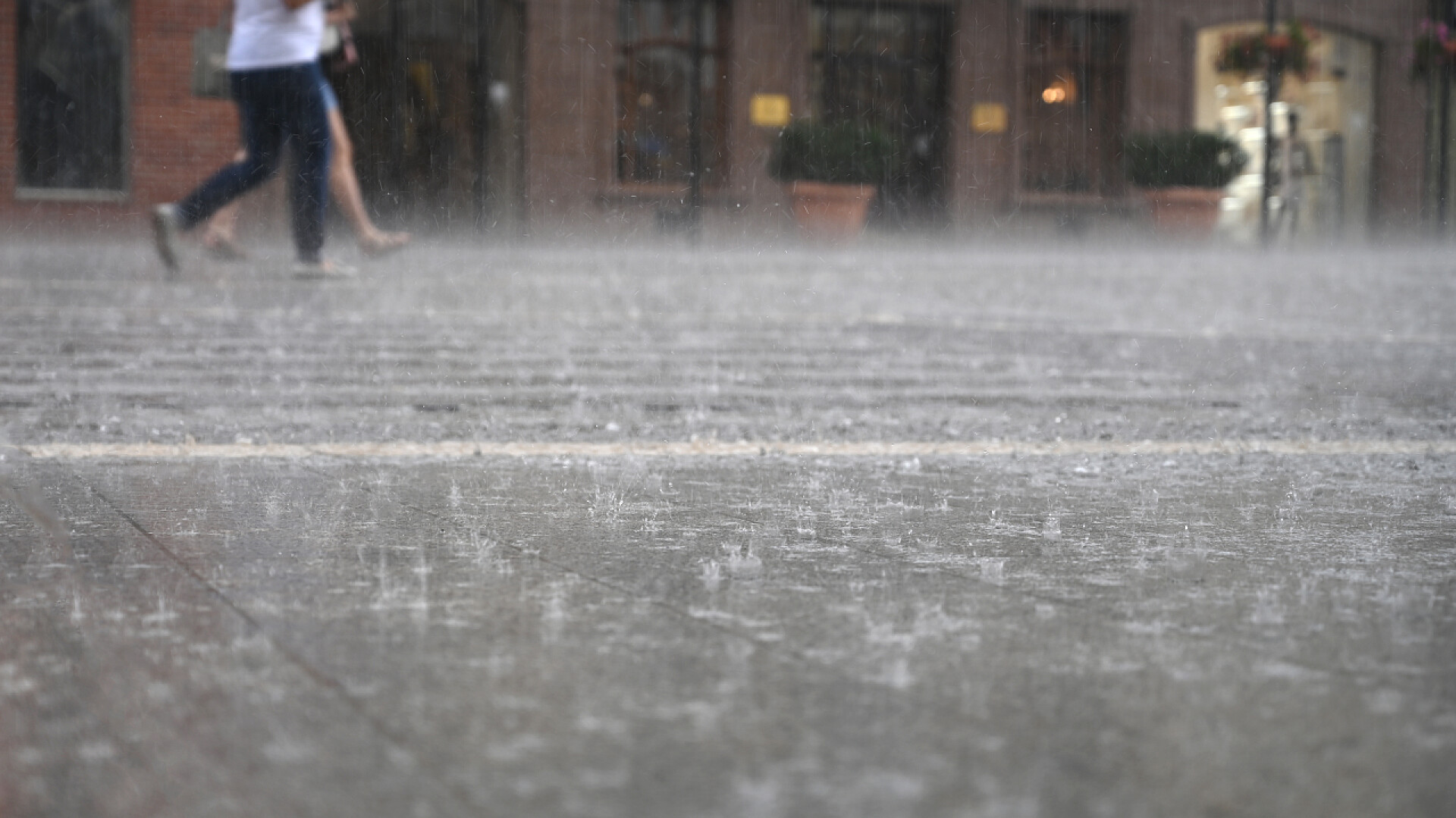 下雨的时候雨滴落在地面一群人在下雨天沿街走着，模糊了方向
