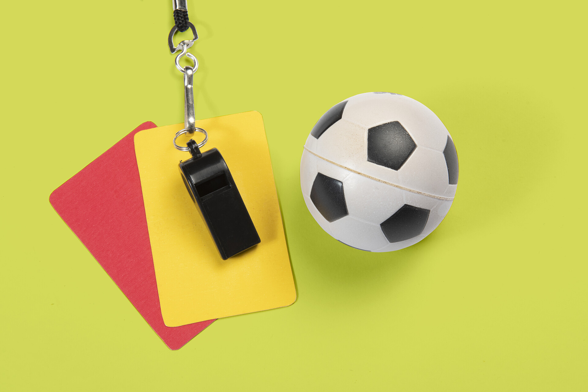 绿色桌子上的足球裁判用品足球、黄牌、红牌和裁判哨子