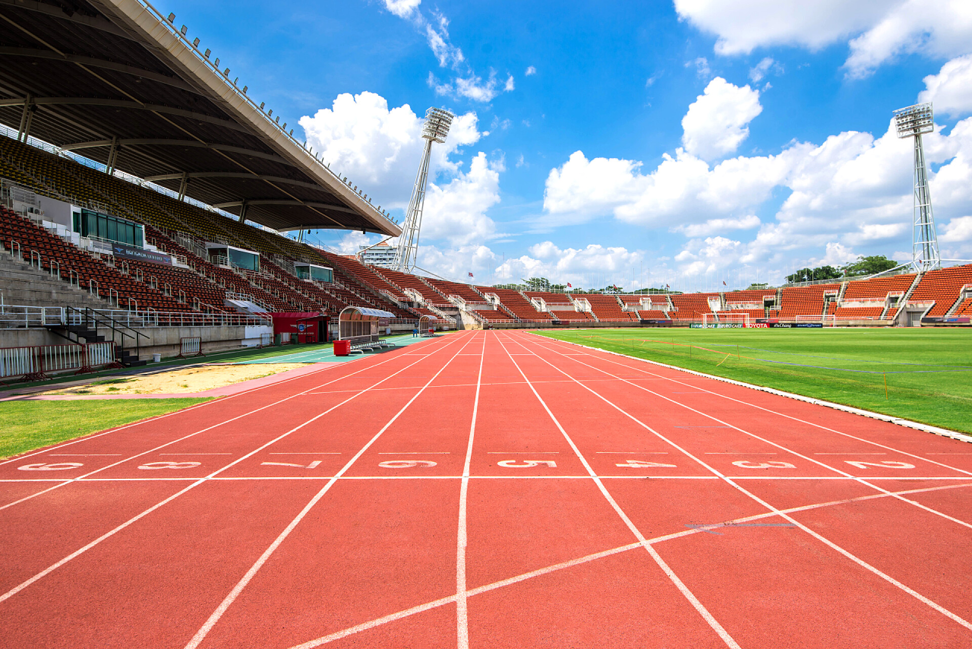 蓝天白云下的跑步赛场从2017年起，体育场从横断面开始的红色跑道起点