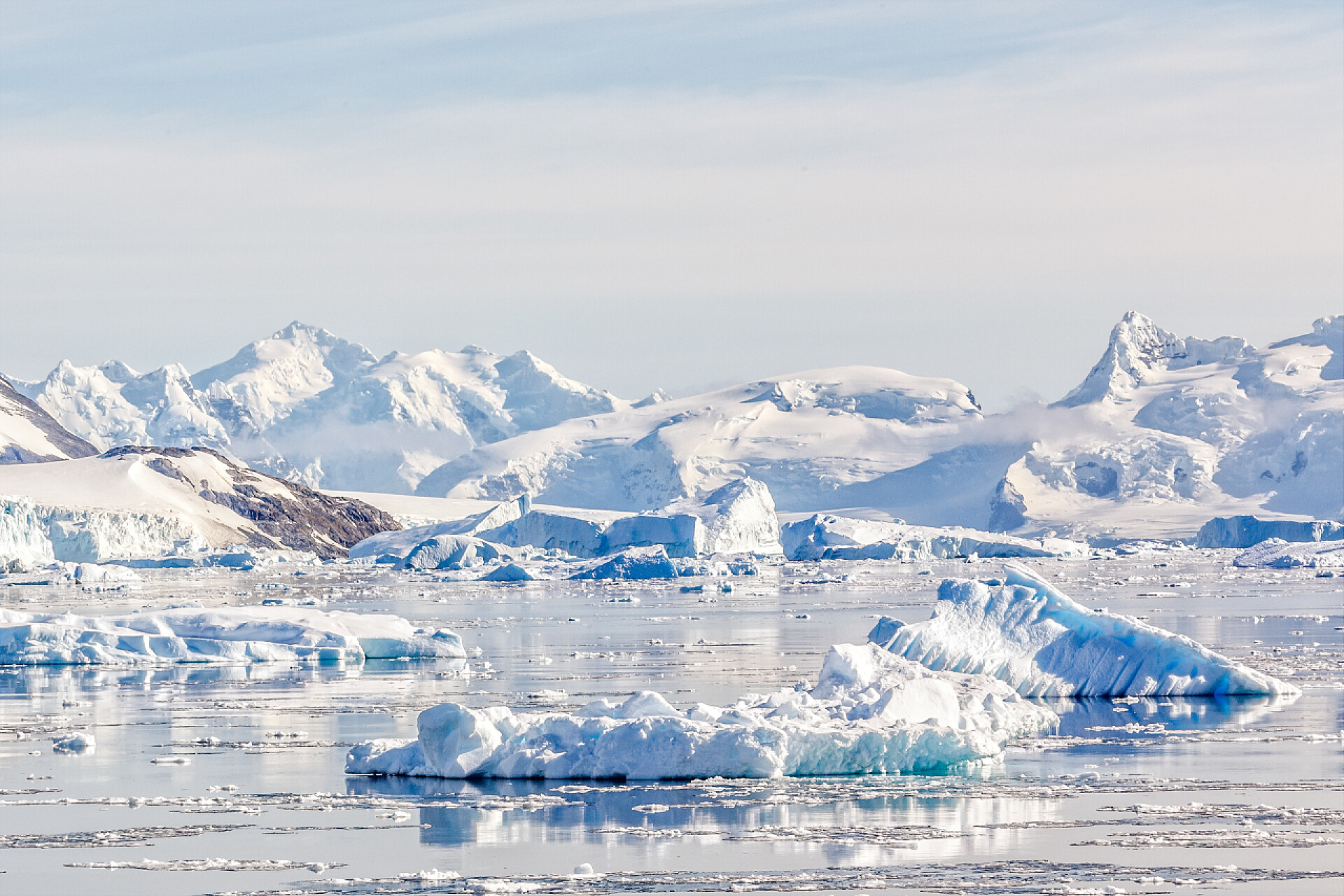 天空下的冰川南极洲的背景是雪山和冰川, 在内科湾平静的水域上的冰山