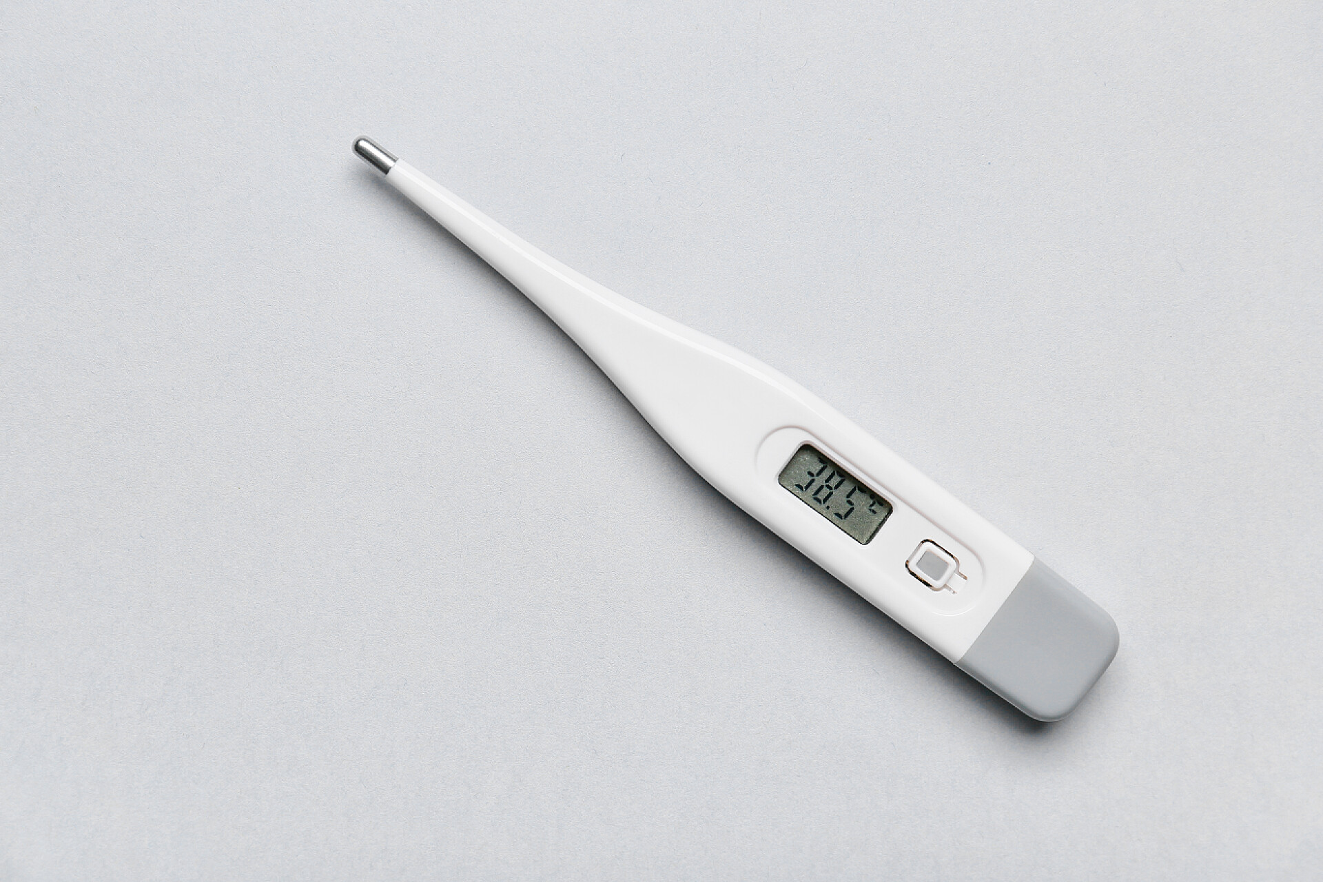 白色桌子上的一个温度计轻背景电子温度计