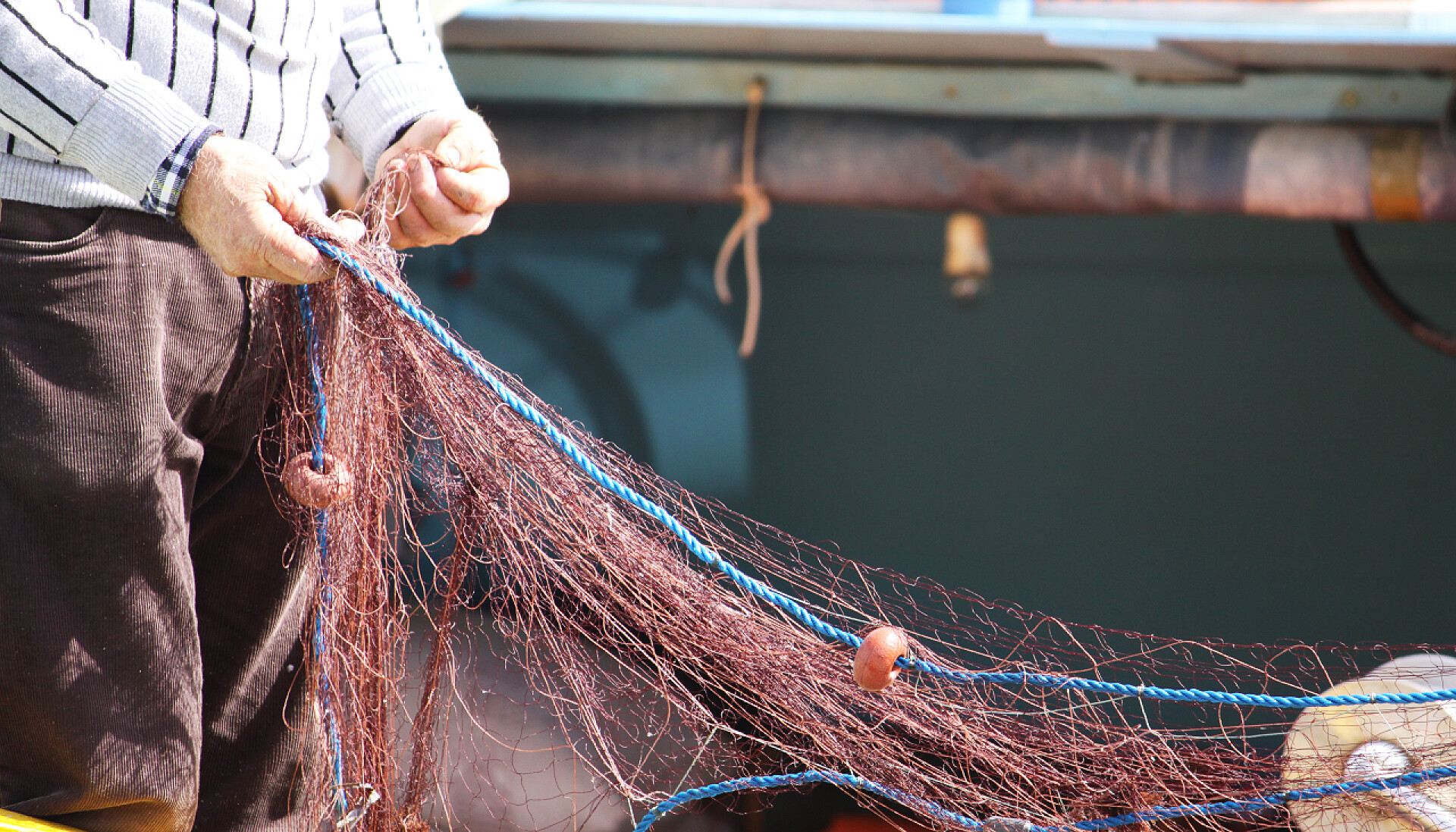 在岸上整理渔网的渔民渔业