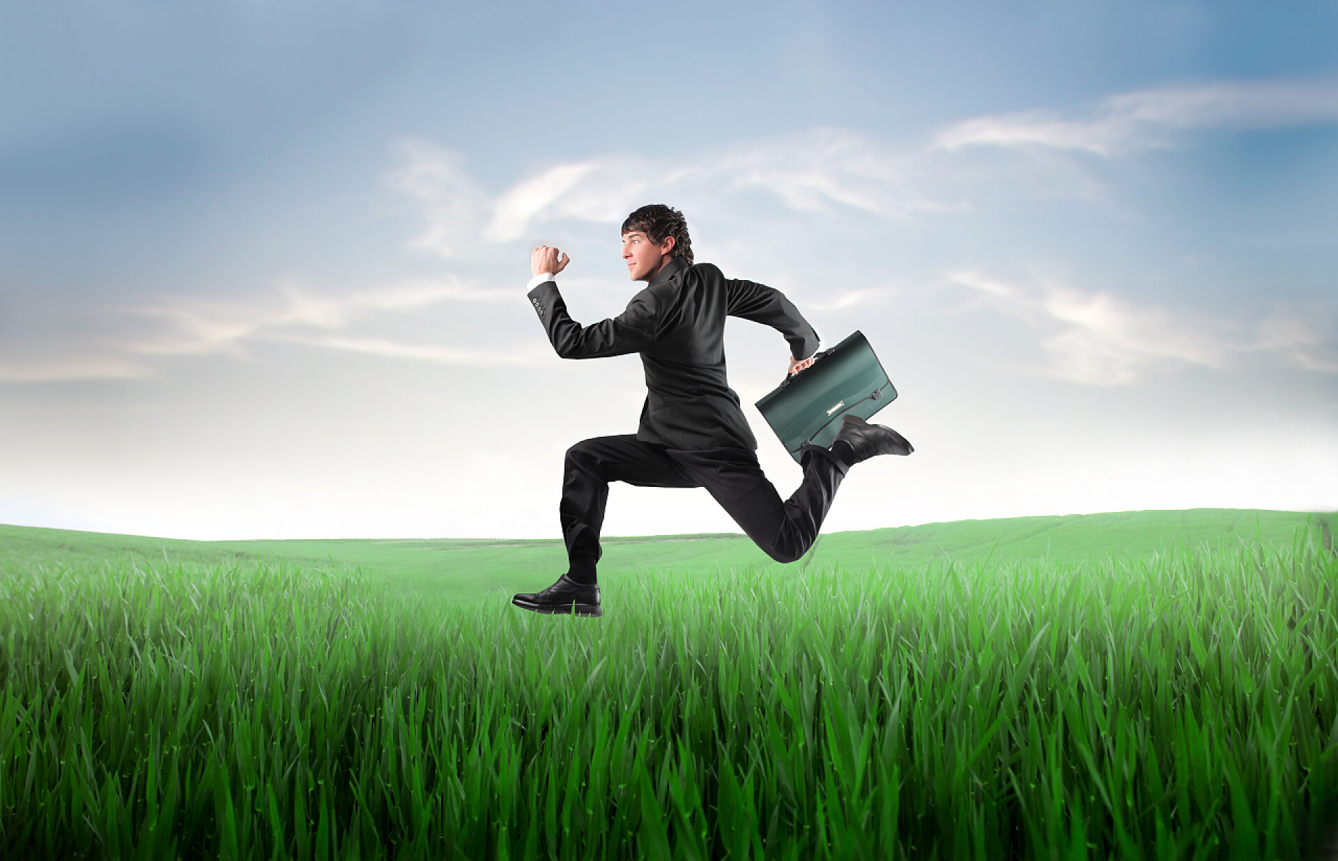 在一片绿色的草地上快速奔跑的商人商务