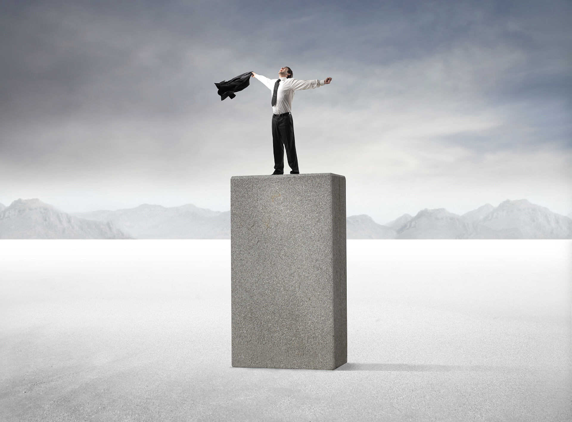 模糊背景上站在石块上的商务男士