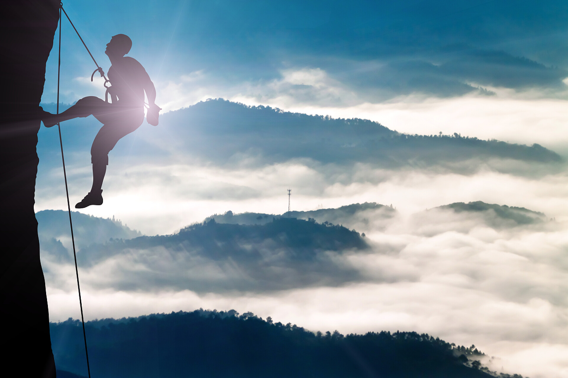 体育运动锻炼登山者在晚霞下爬山的剪影