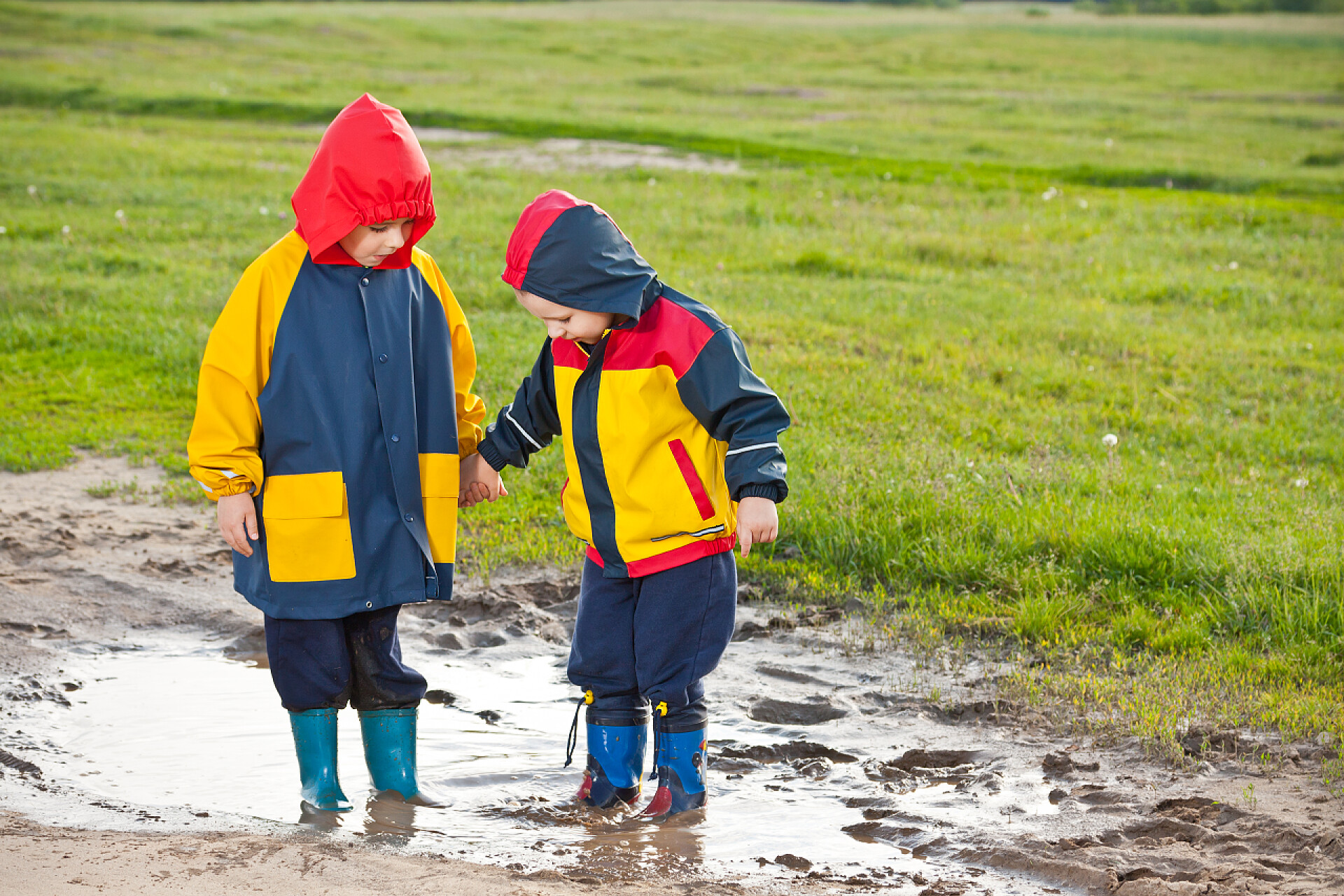 两个年轻兄弟手牵着手在水坑里儿童