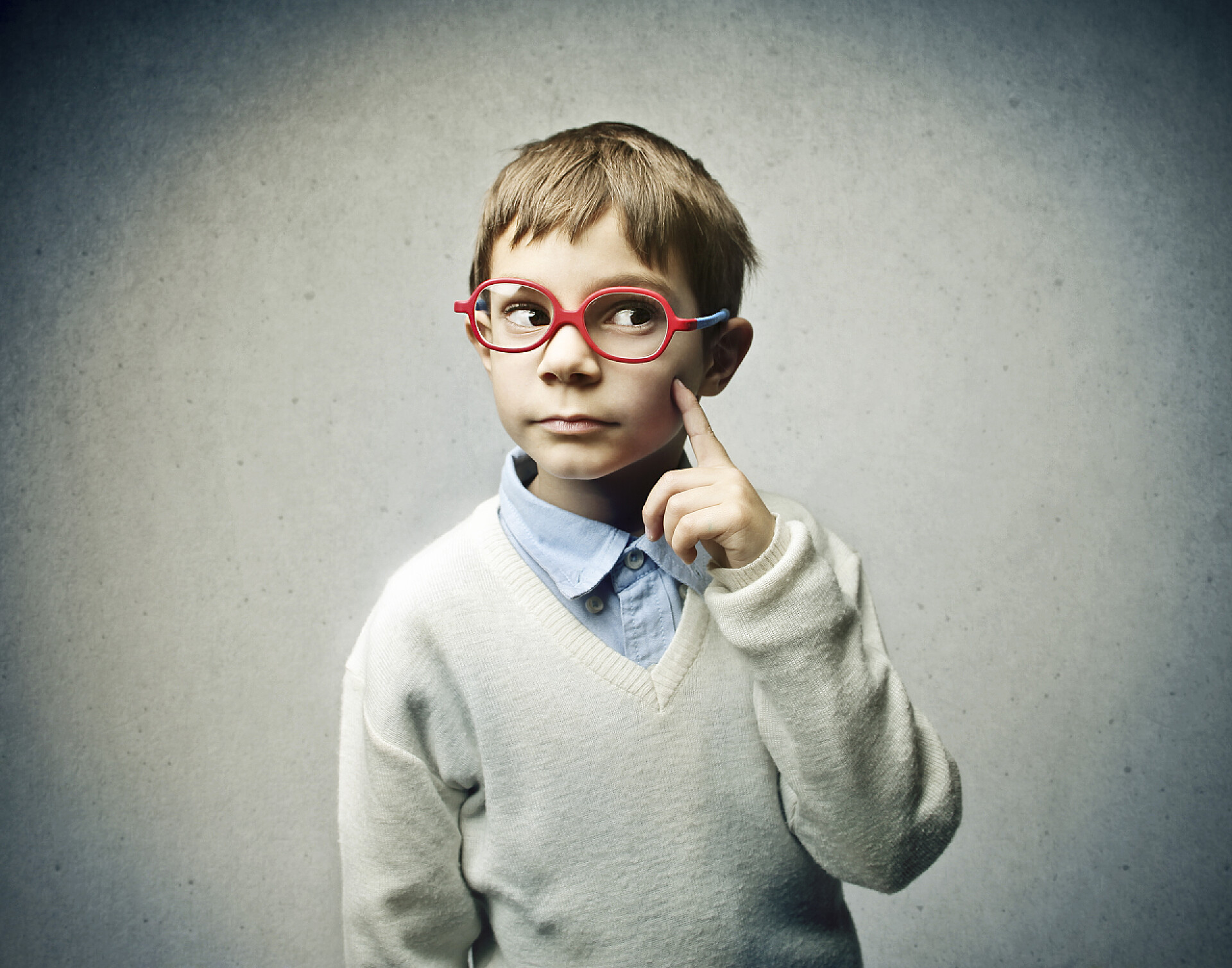 灰色背景上的思考的小男孩