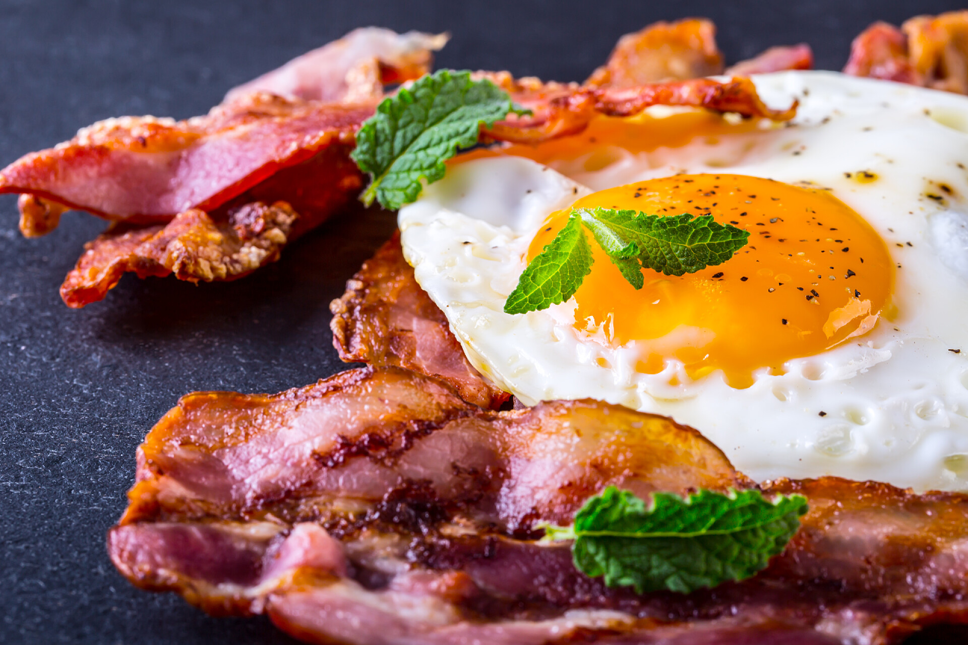 黑色背景上的培根鸡蛋食物