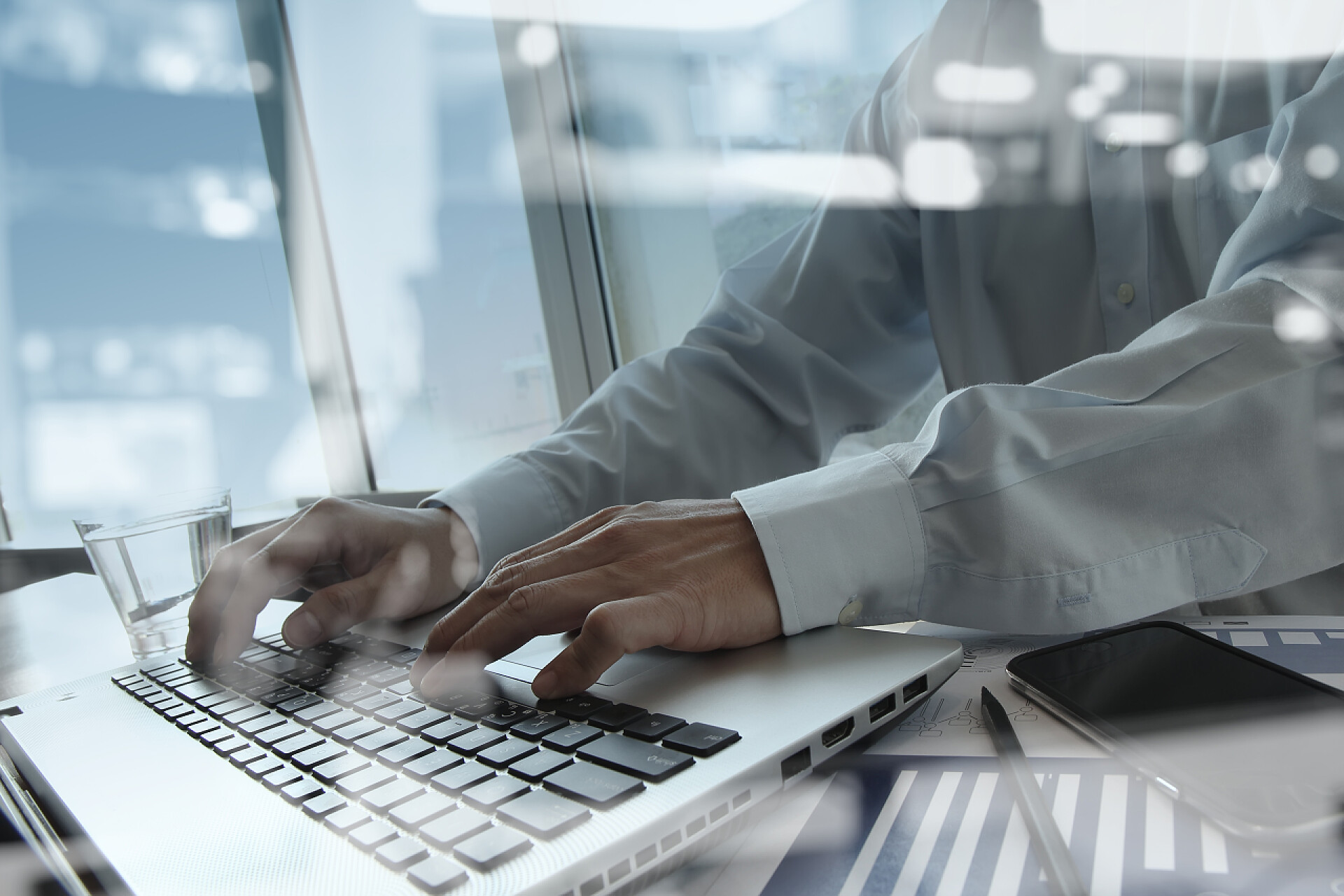 商务人士在用笔记本电脑打字商人手工操作的双重曝光--以现代计算机和商业新战略为概念