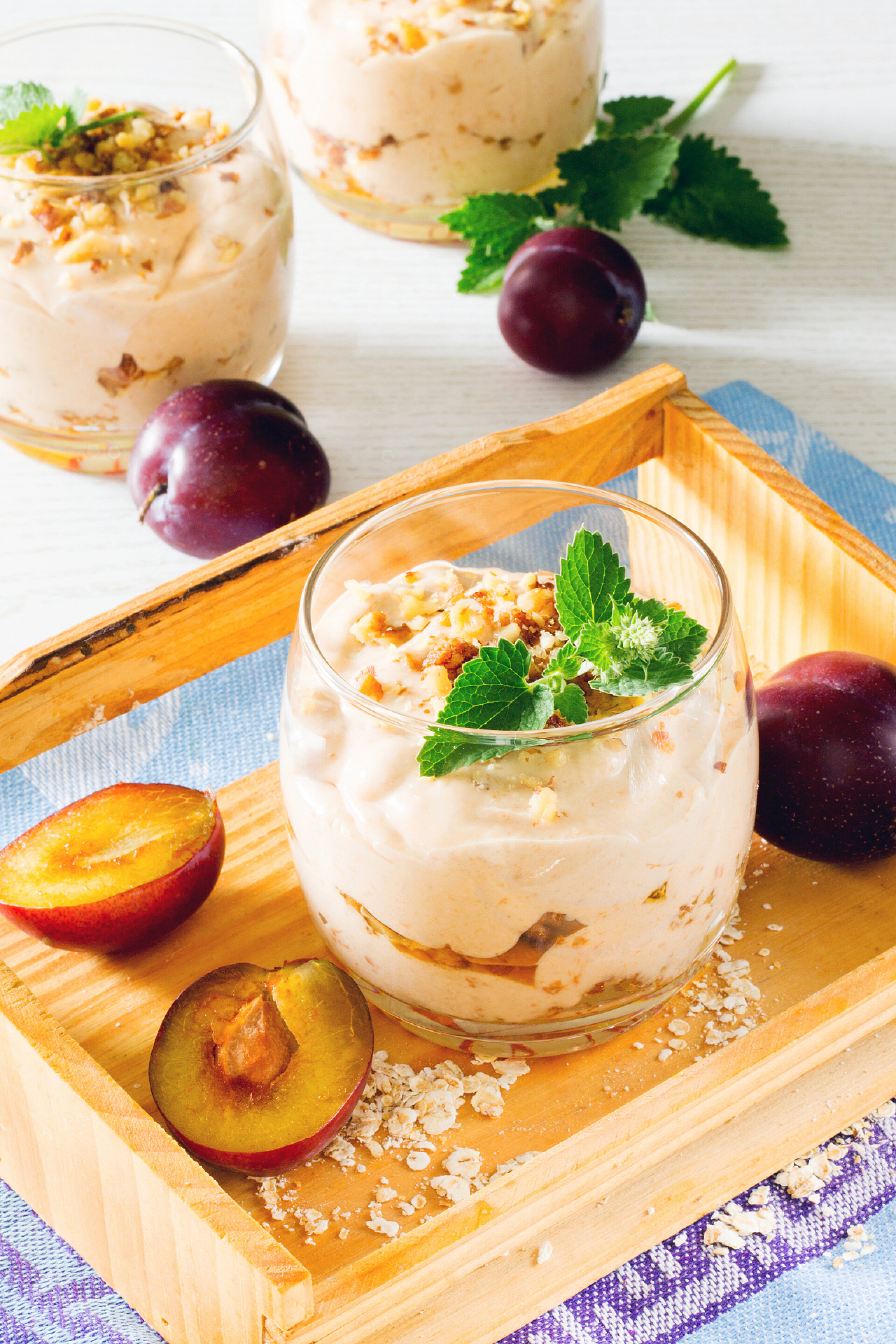 营养均衡在木制的桌子上的烤坚果燕麦酸奶和李子