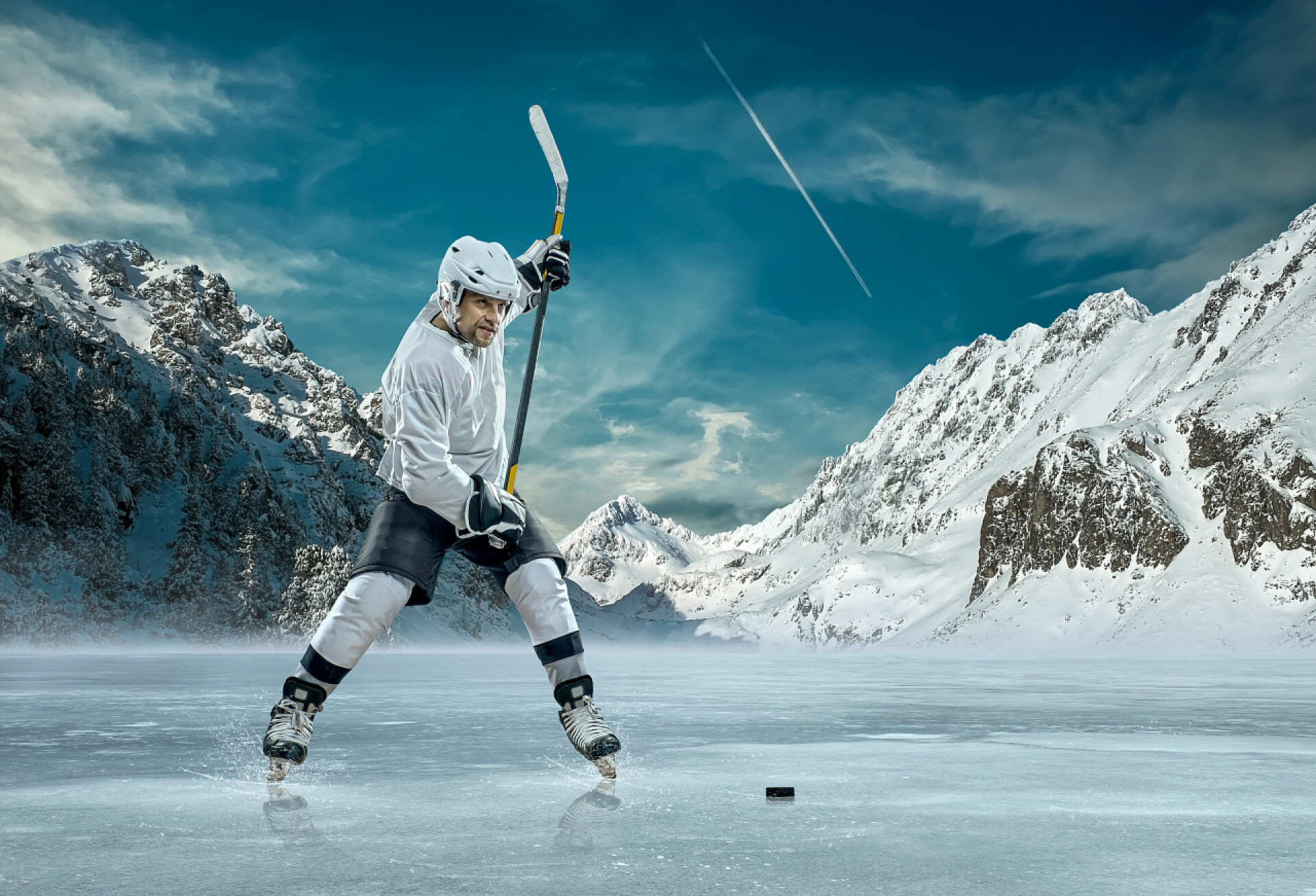 体育运动锻炼冰上曲棍球球员在室外周围群山的冰上训练