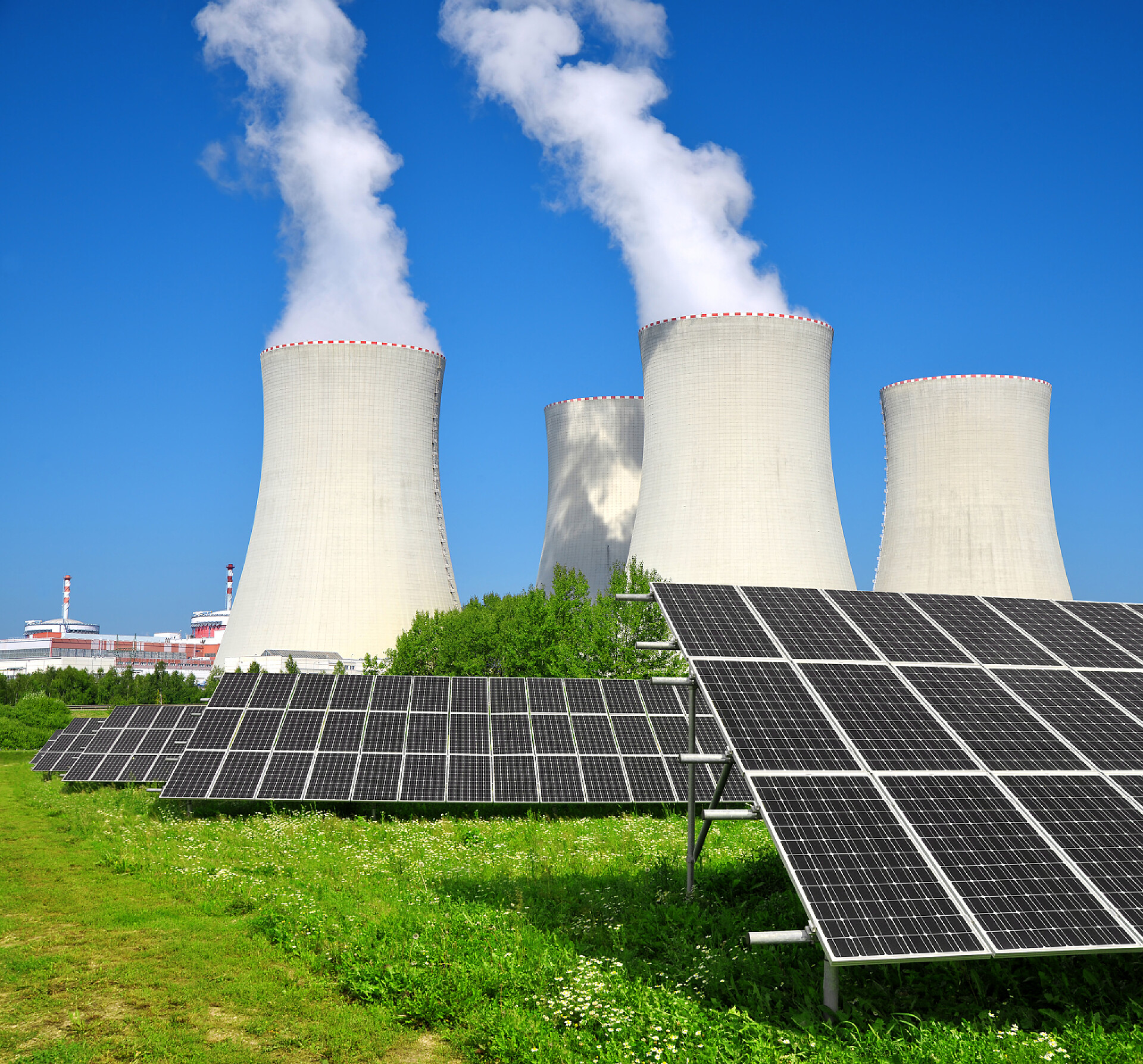 蓝色天空下太阳能板前核发电厂