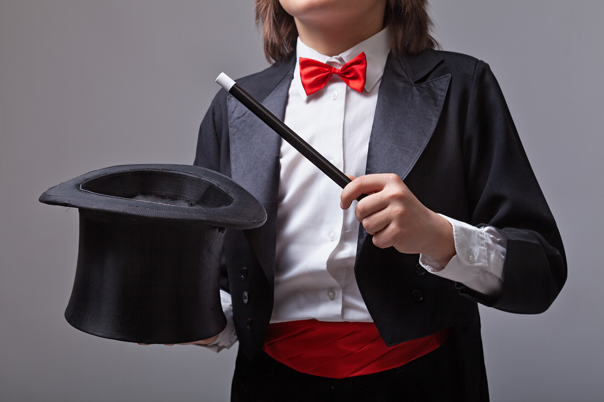 优雅的魔术师拿着魔术帽和魔杖特写