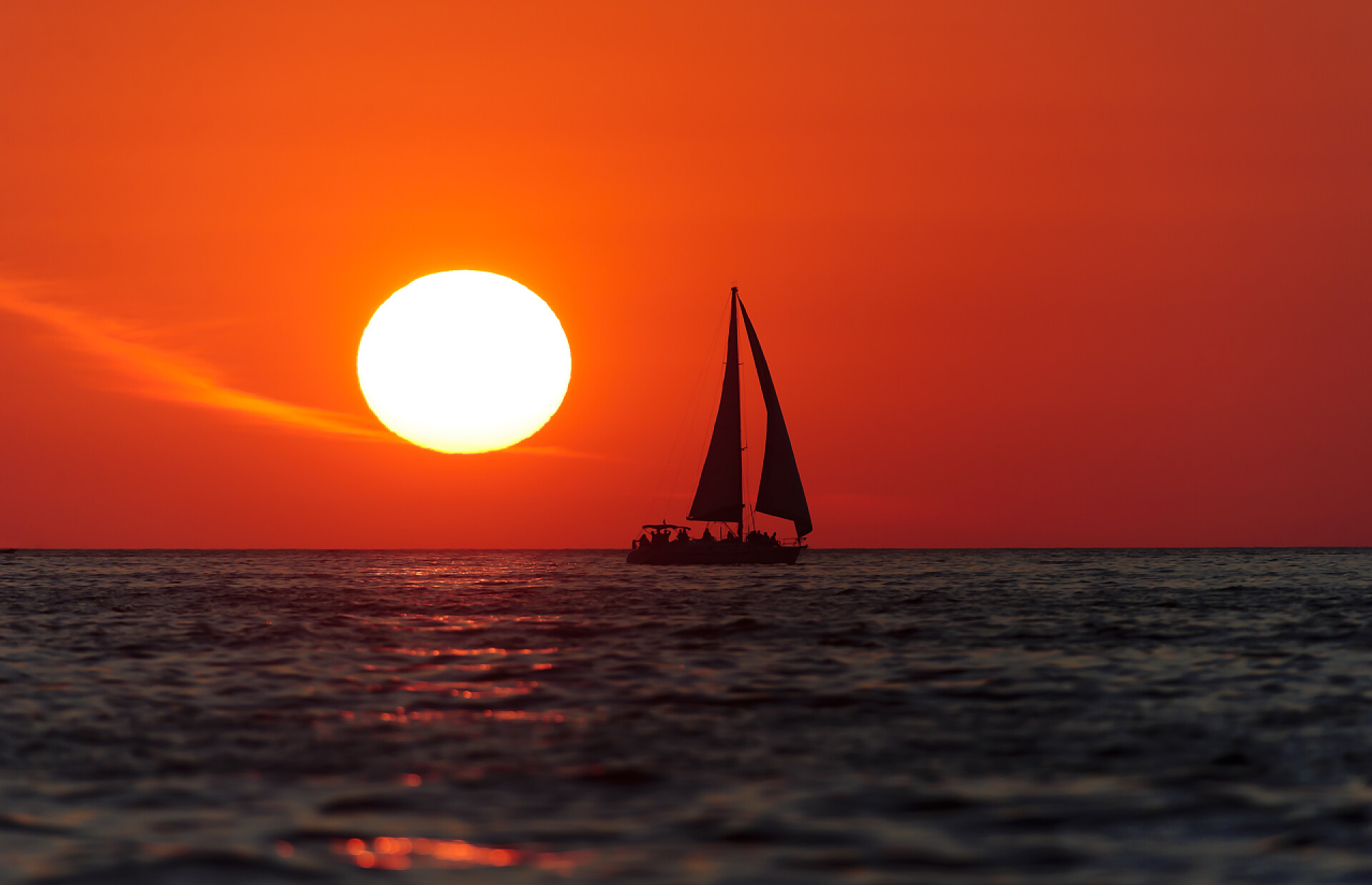 夕阳下一艘帆船在海面上行驶