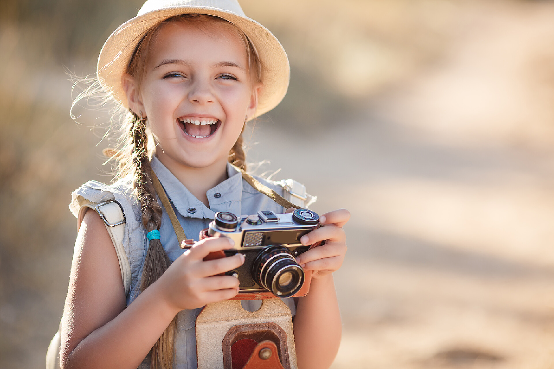摄影摄像人物生活拿着一台旧相机的女孩与旧的棕色手提箱和一台旧相机6岁的女孩率手， 金色的黑发梳两条辫子，戴着草帽的烈日在蓝色的飞行套装、 自然照片虽然旅游，站在一条乡间小路