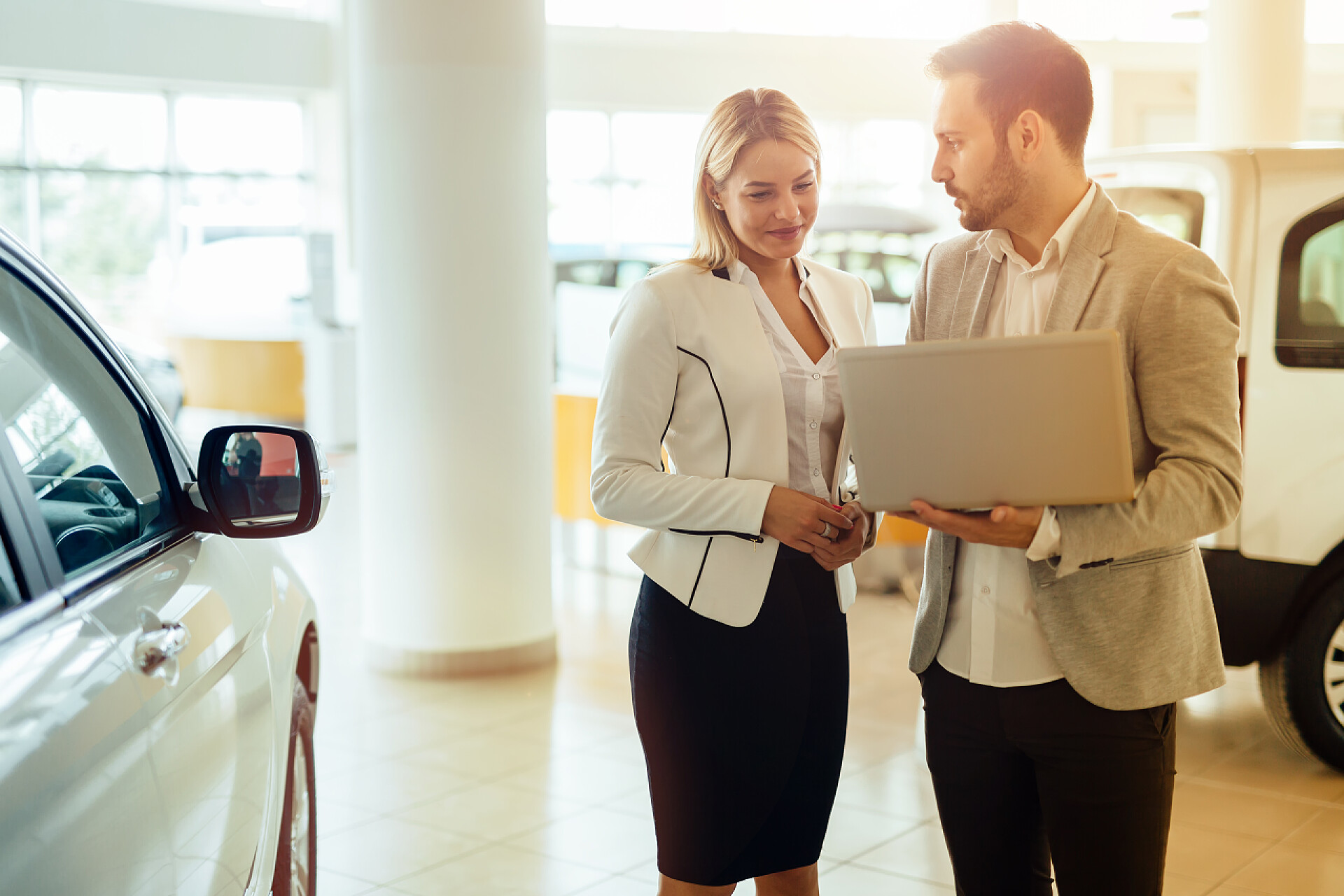 专业的汽车销售人员向女人出售汽车
