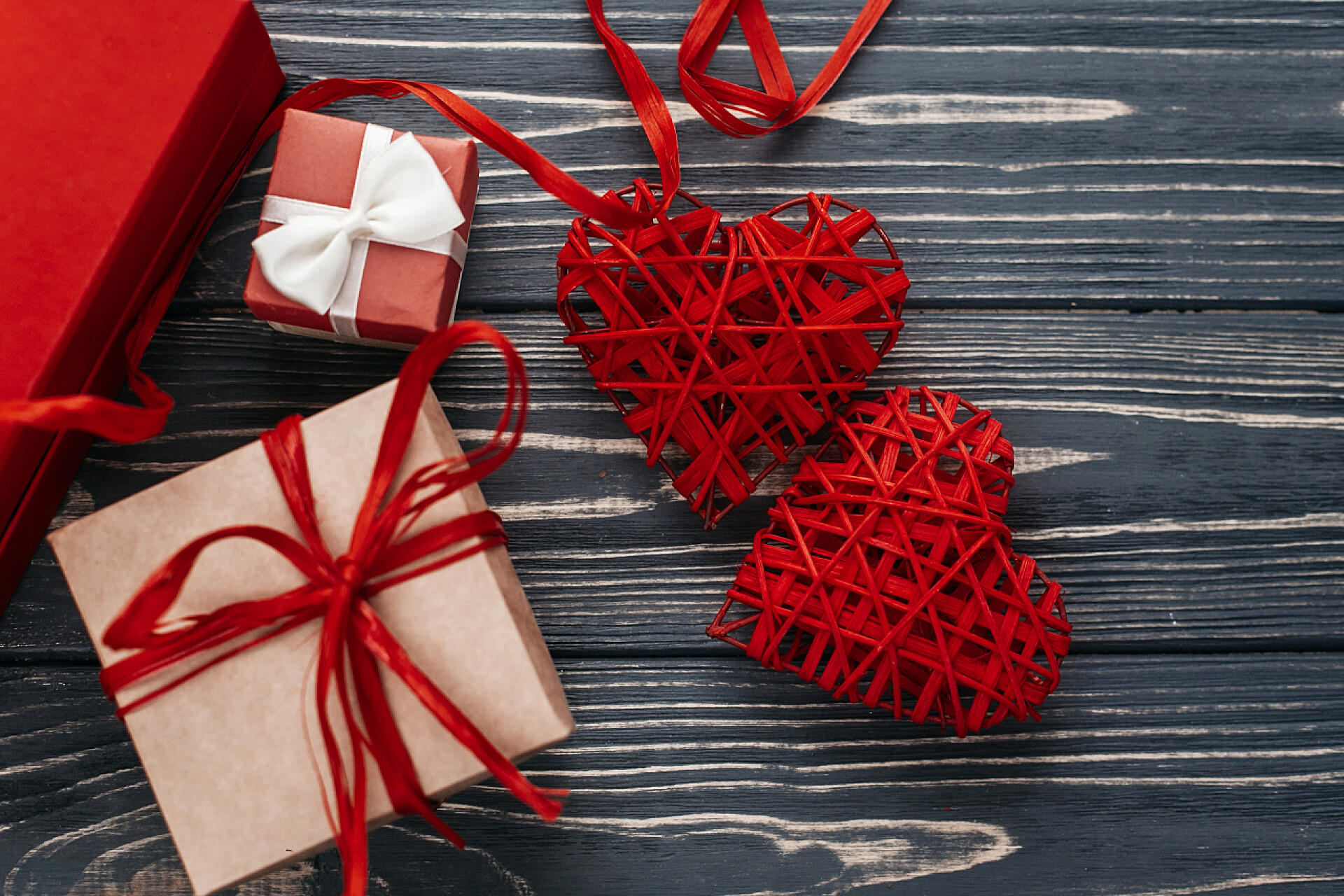 仿古木制背景上的两个心丝带礼盒