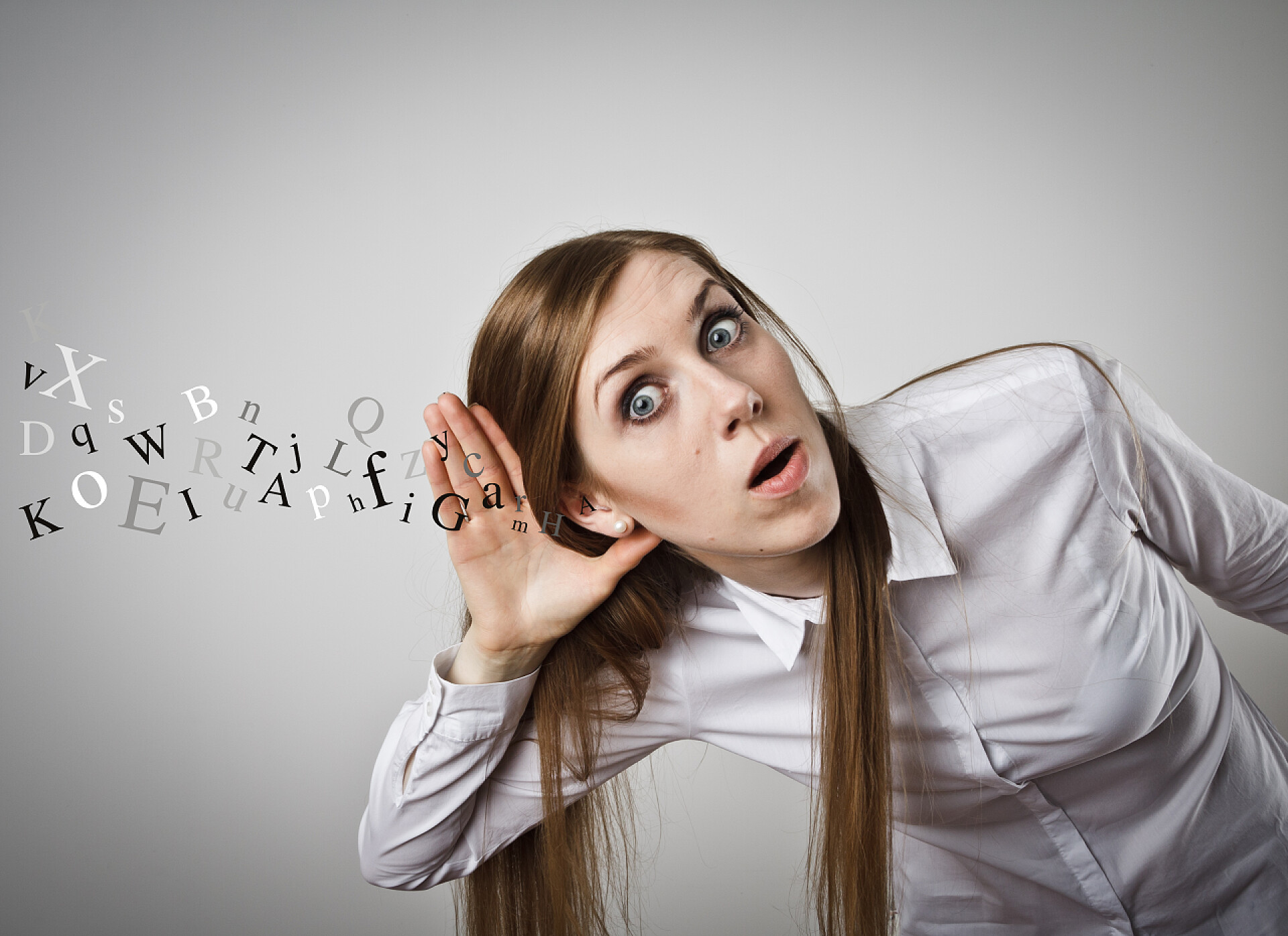 灰色背景下侧身倾听的女人