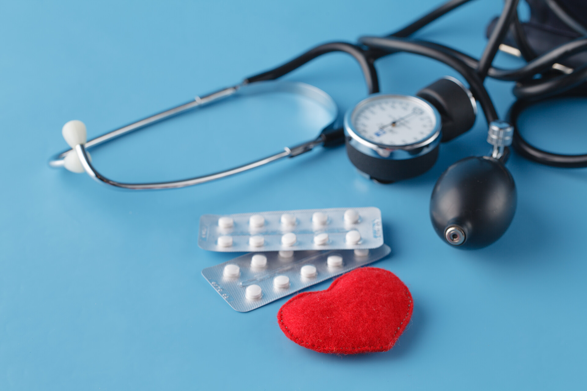 蓝色桌子上摆放药品和听诊器提醒卫生保健