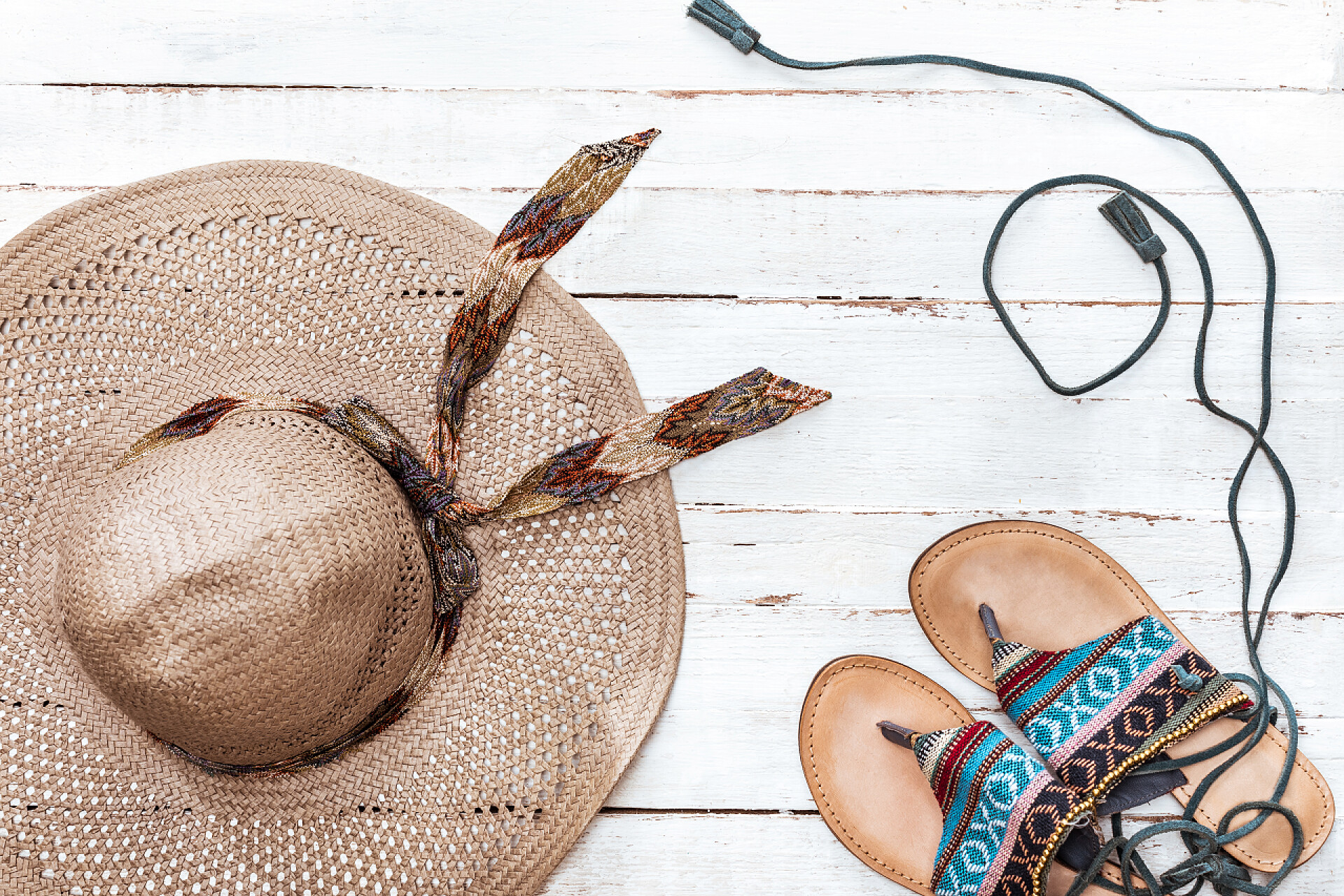 度假旅行顶视图的草帽和拖鞋在白色的木桌上