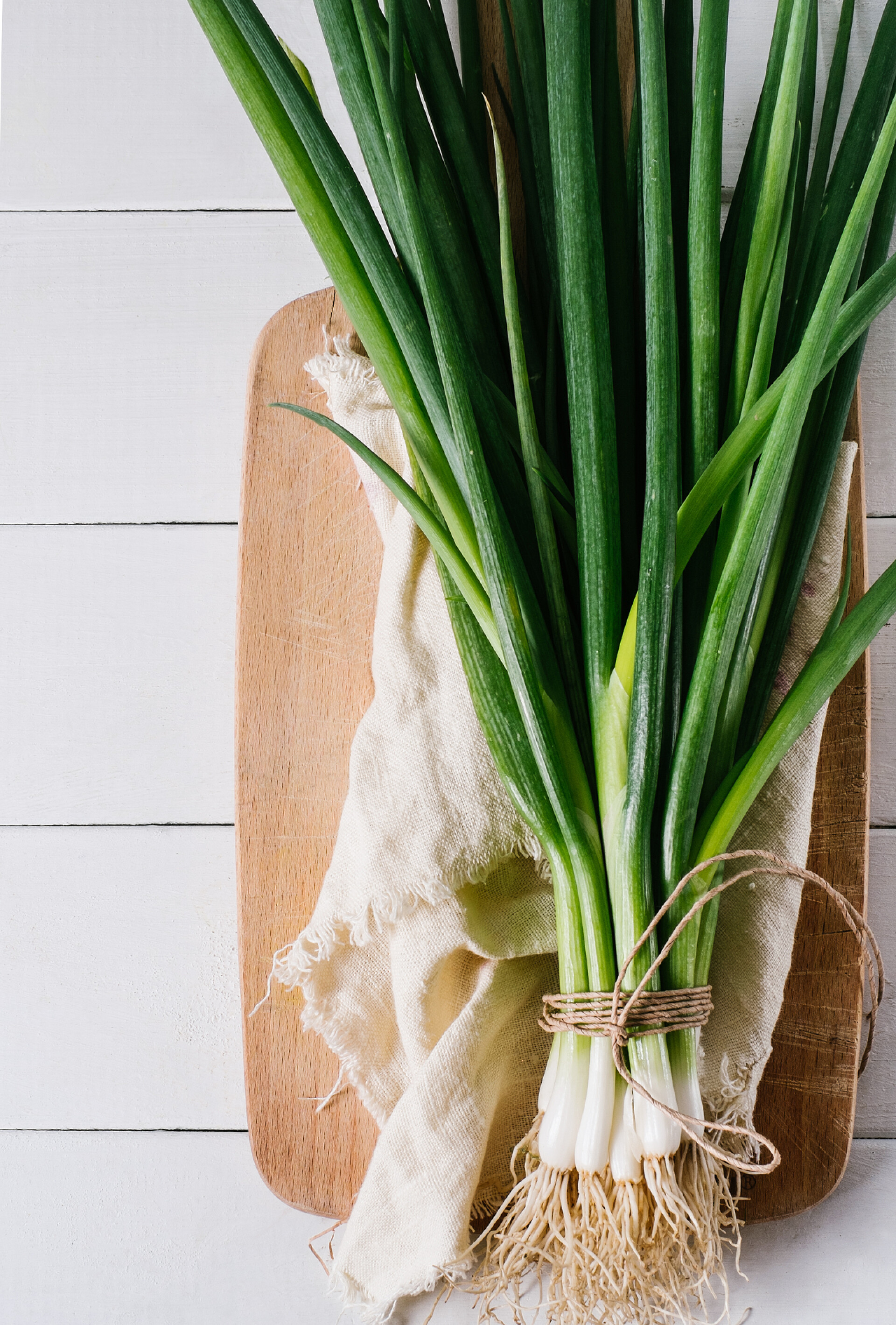 蔬菜白色背景上的切菜板放着的小葱的顶视图
