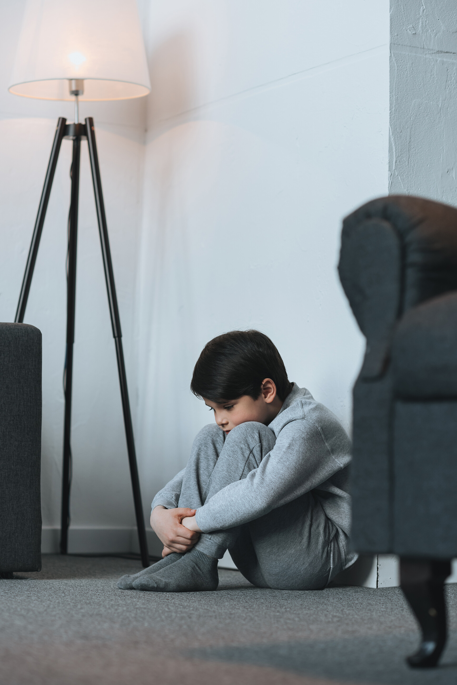 一个烦恼的小男孩坐在角落里发呆