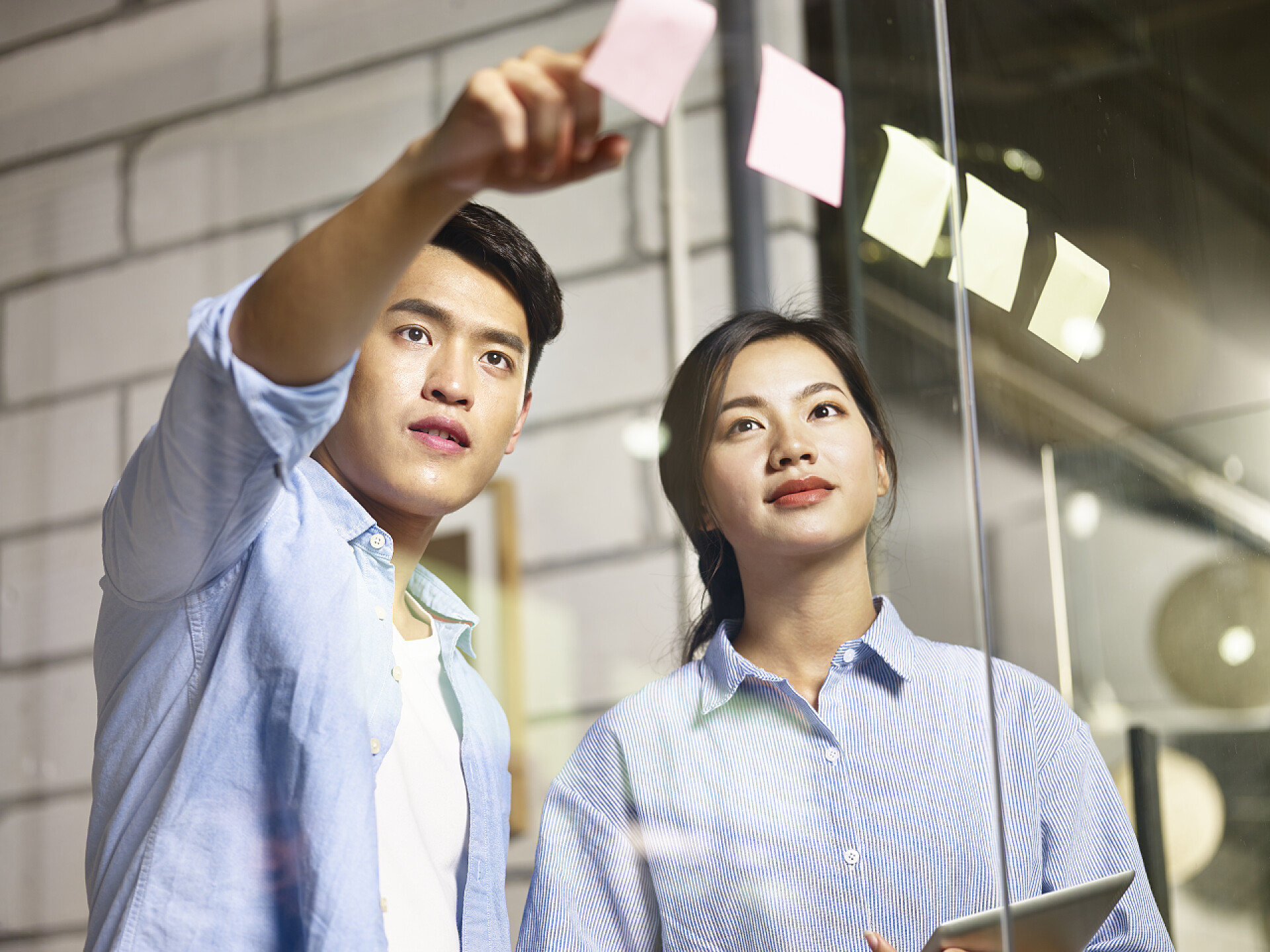 商务两个人在办公室粘贴便利签