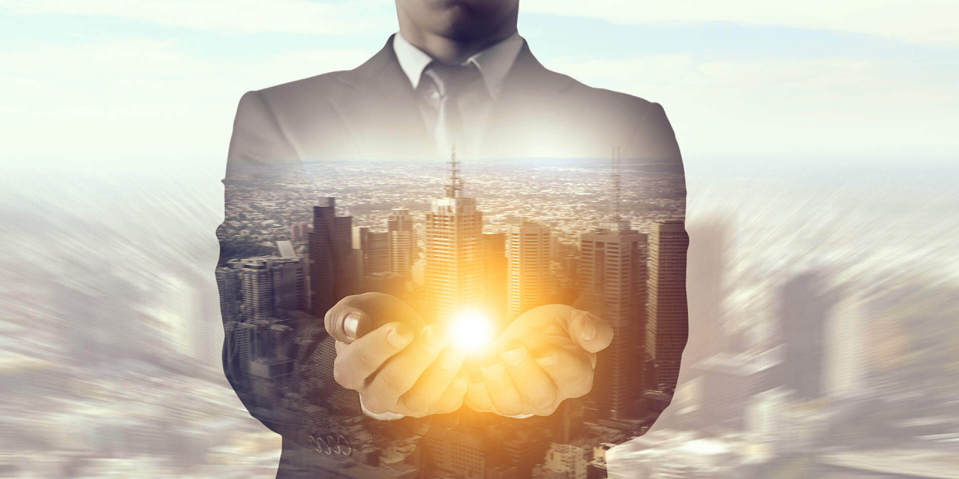 商人托举亮光和现代城市景观概念图