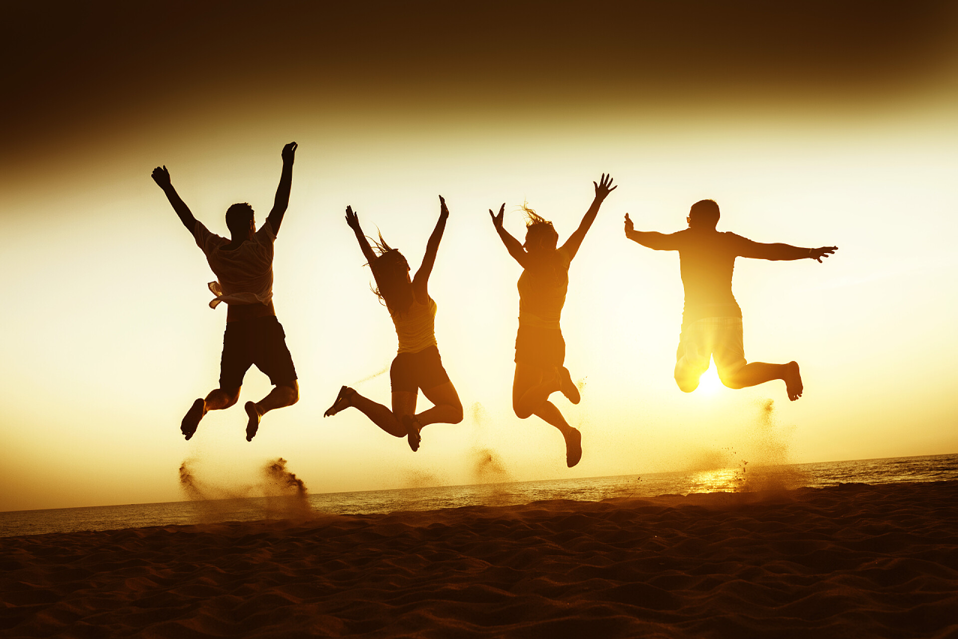 黄昏时分在海边开心跳跃的人