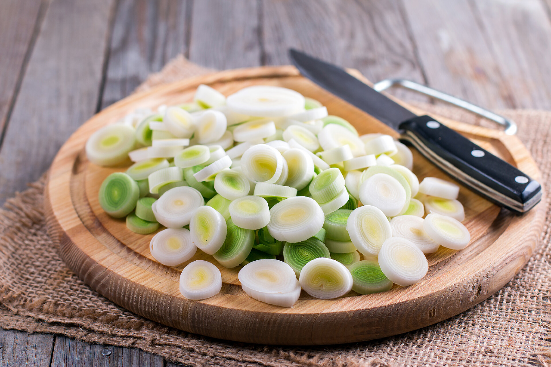 蔬菜韭菜在木砧板上被切成圆形状