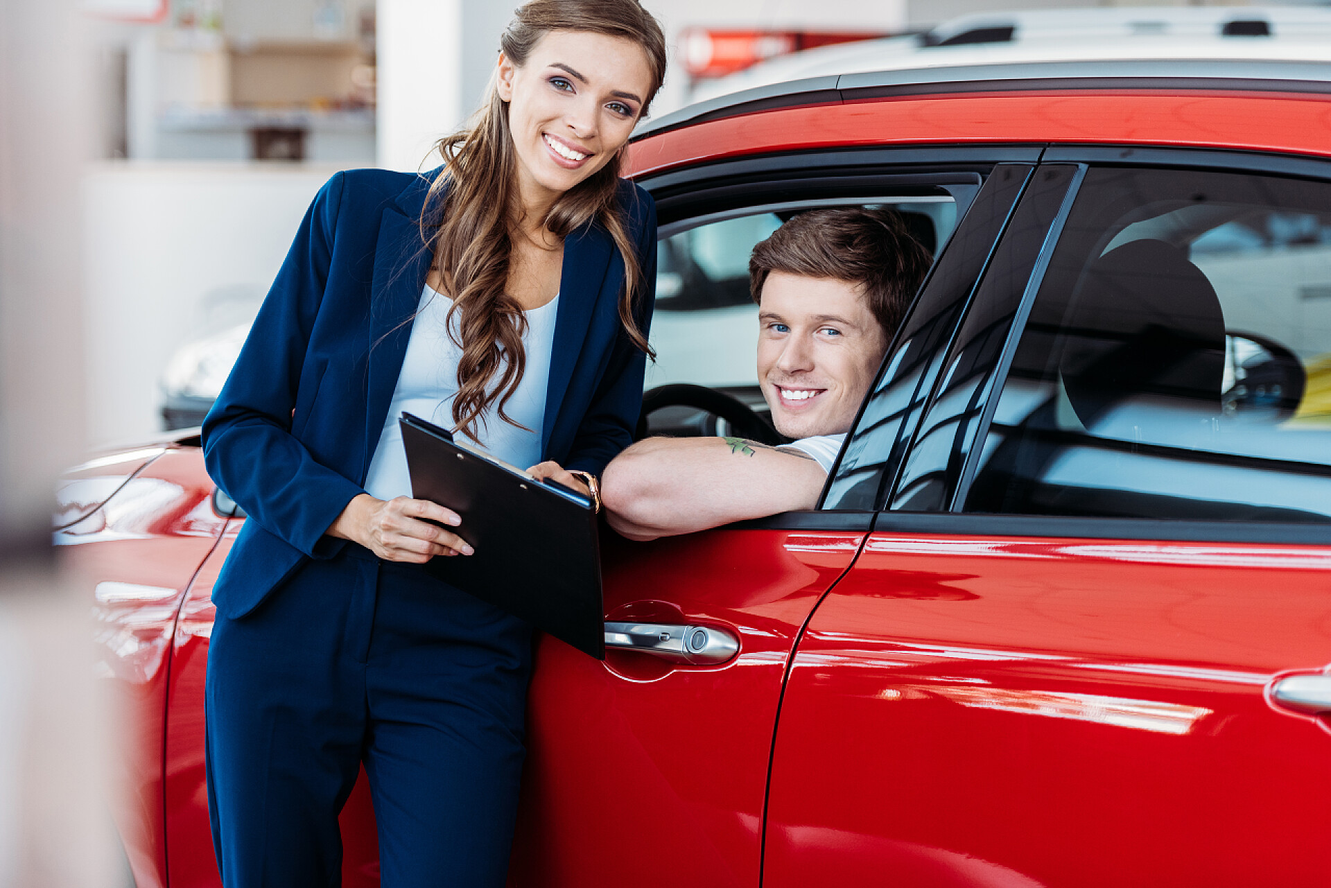 商务顾客坐在车里听销售经理讲解买车