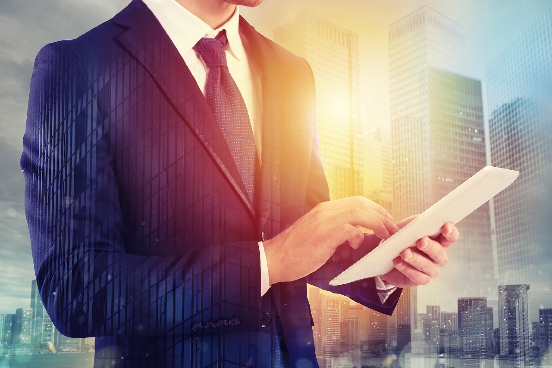 商务男士手拿平板和身后大厦