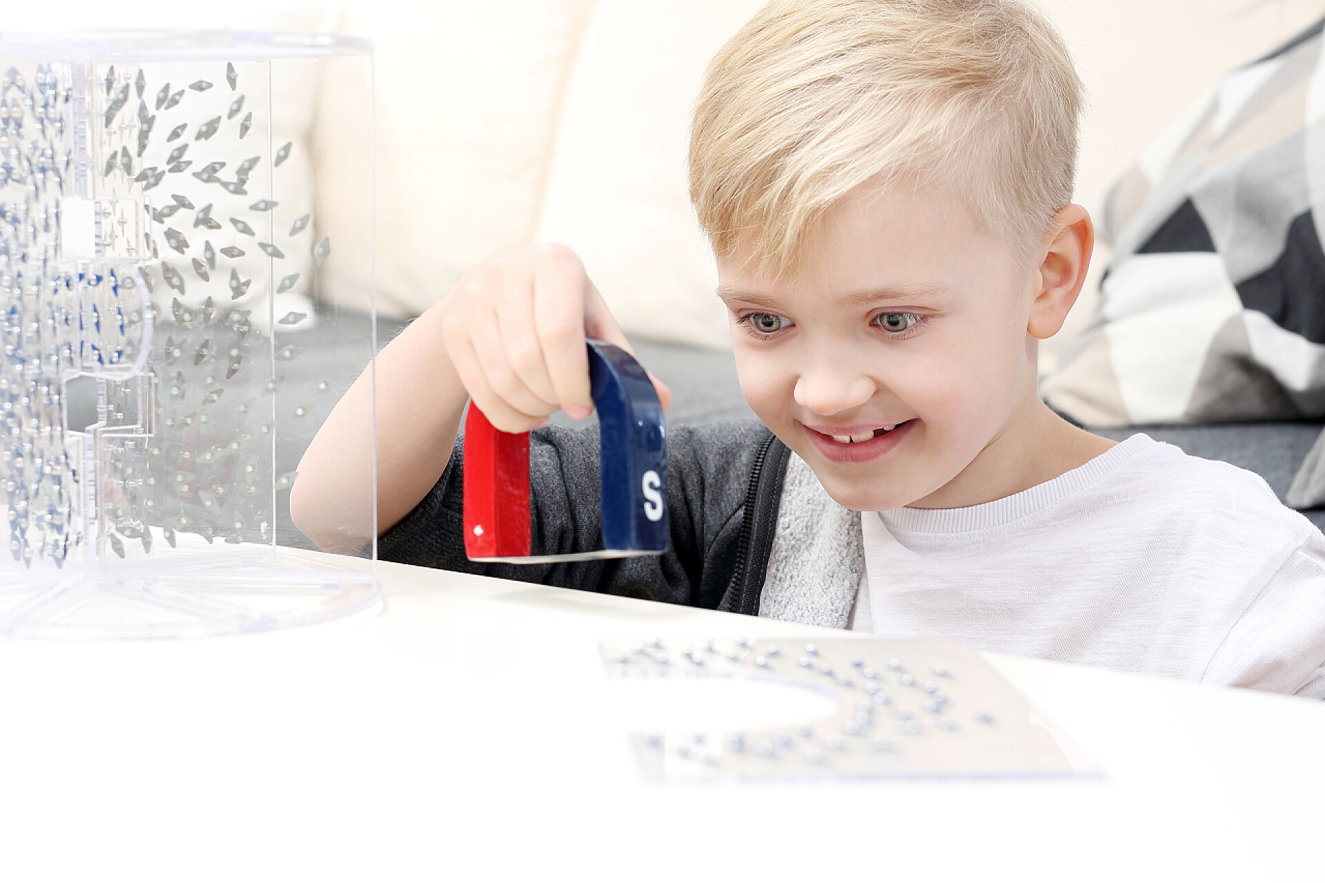 一个小男孩在客厅玩磁铁