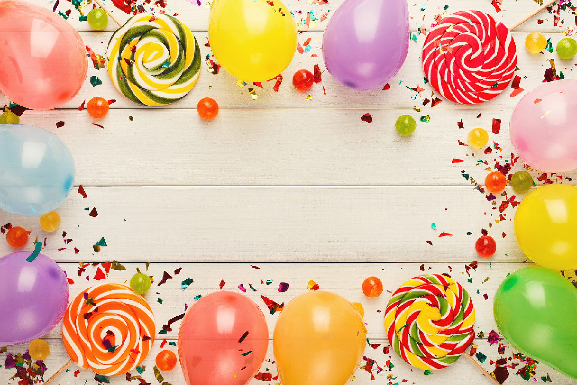 乡间木板上彩色棒棒糖纸屑和彩色气球