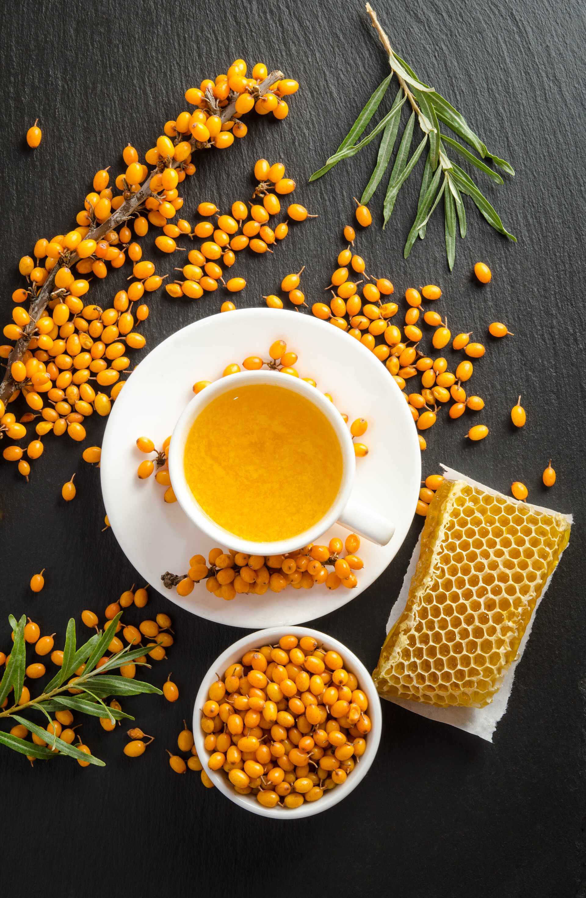 饮品黑色木桌上的沙棘和蜂蜜做的果茶