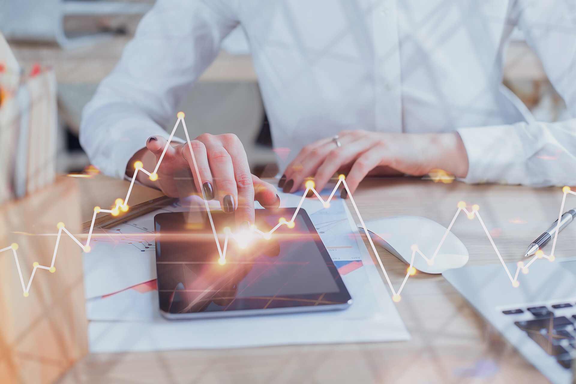 商务人士用放置在办公桌上的平板电脑看外汇图