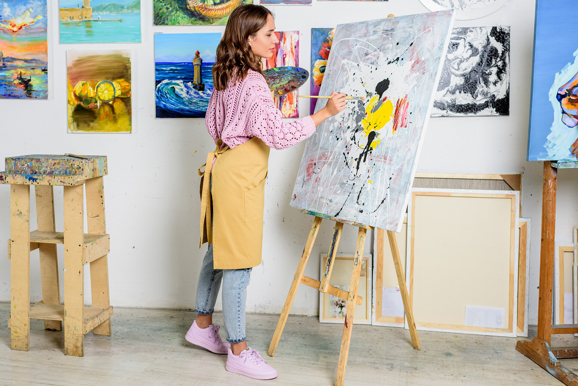 美丽的女画家在车间画布上做画