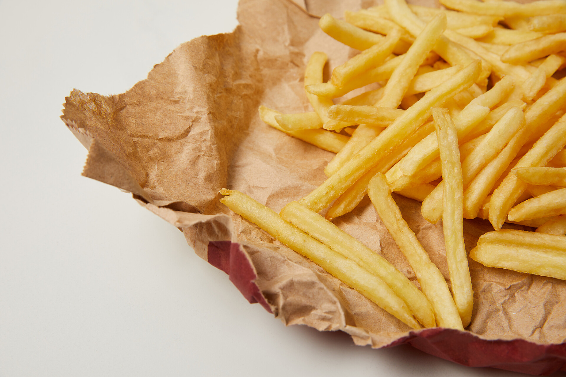 美味的食物法式薯条在皱巴巴的纸上特写镜头